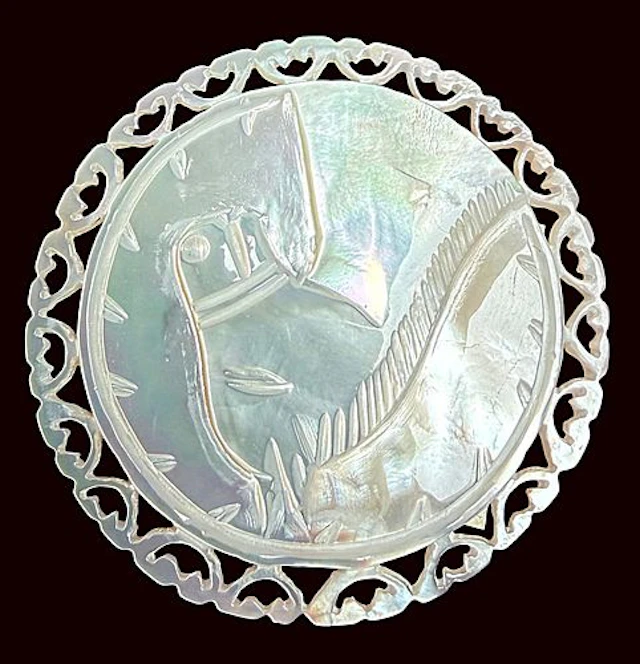A DIVISION THREE CARVED PEARL PICTORIAL BUTTON