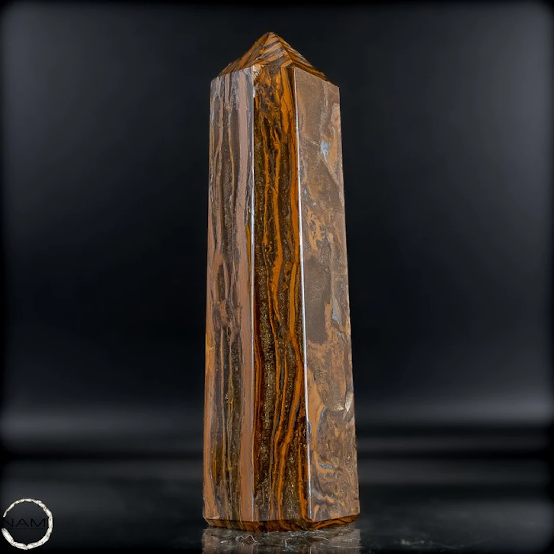 Natural tiger's-eye obelisk with a golden-brown silky texture.- 1141.36 g