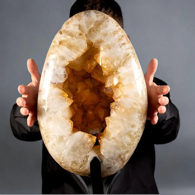 Golden citrine crystals set in a polished quartz geode egg