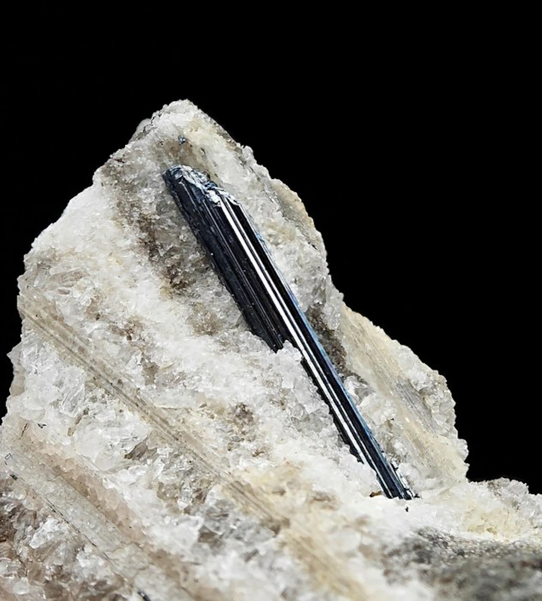 Rare, lustrous stibnite set in red fluorescent calcite