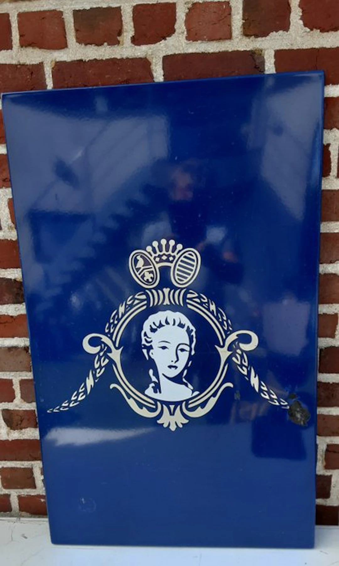 Enamel sign with the emblem and the portrait profile that...