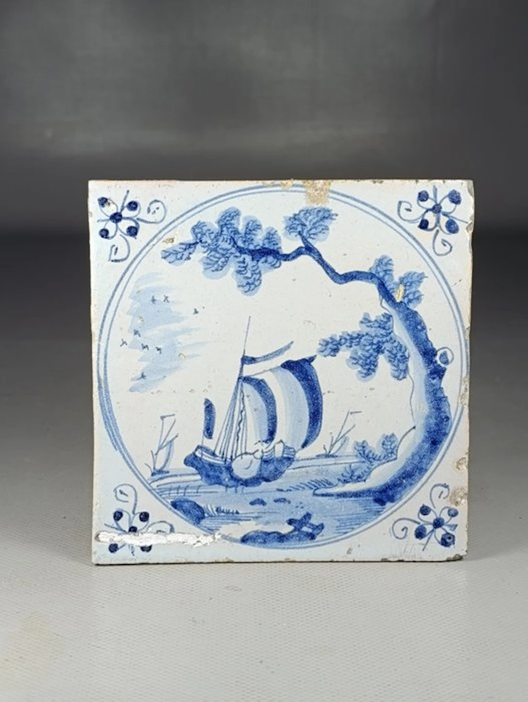 Tile - boat motif under a pine in a circular medallion - the 18th century