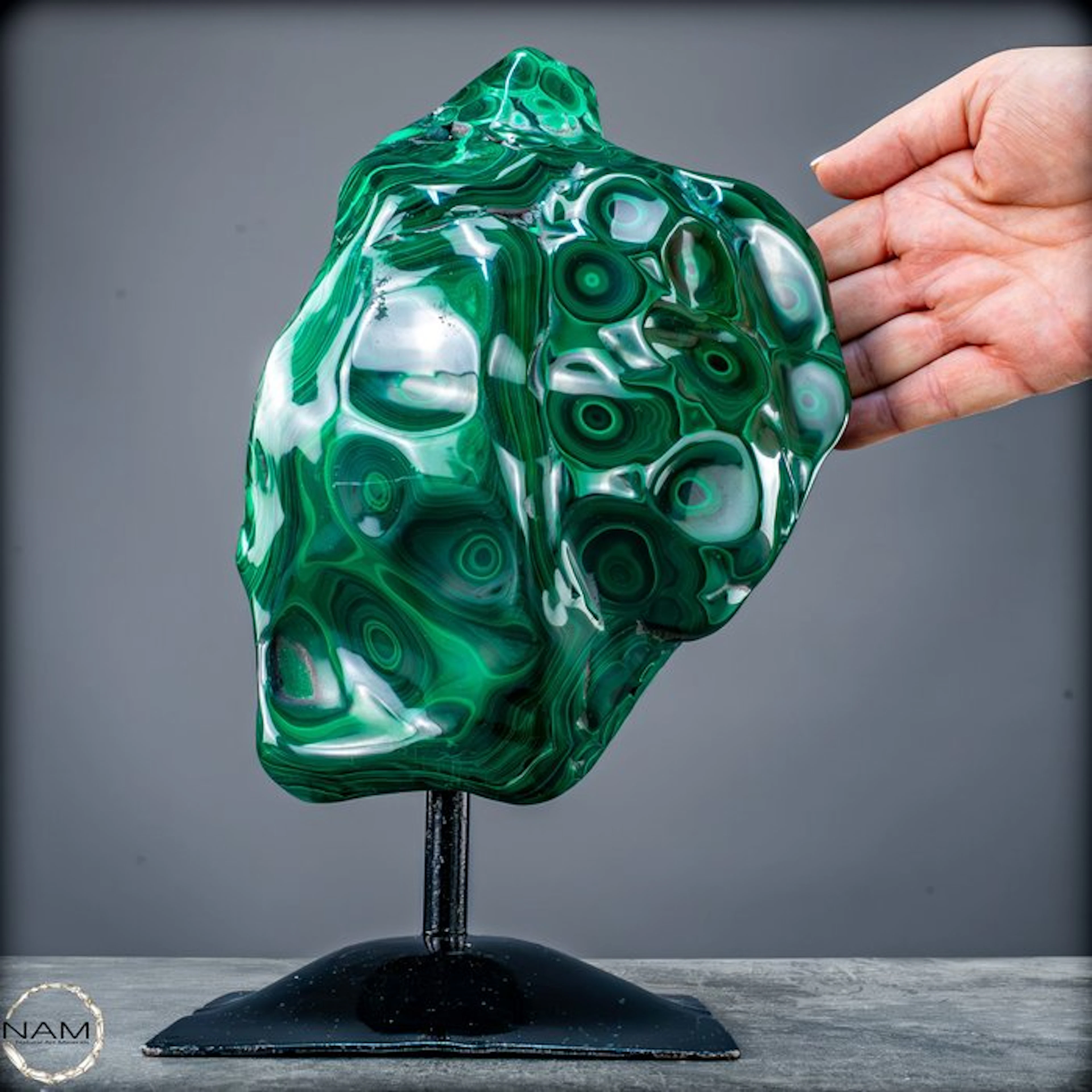 Malachite sculpture with a pronounced eye pattern on a...