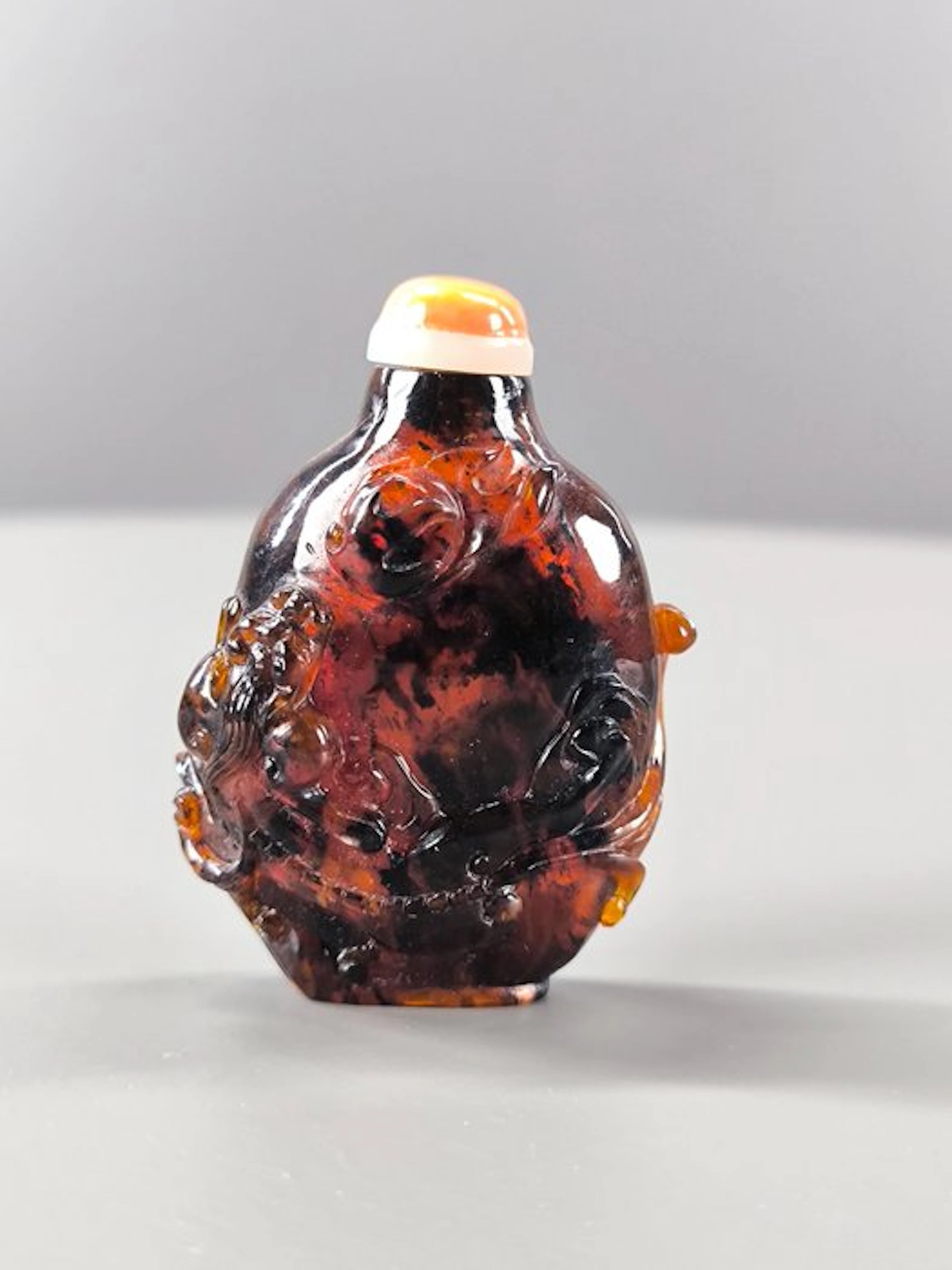 chine Translucent brown-orange amber with dark inclusions
