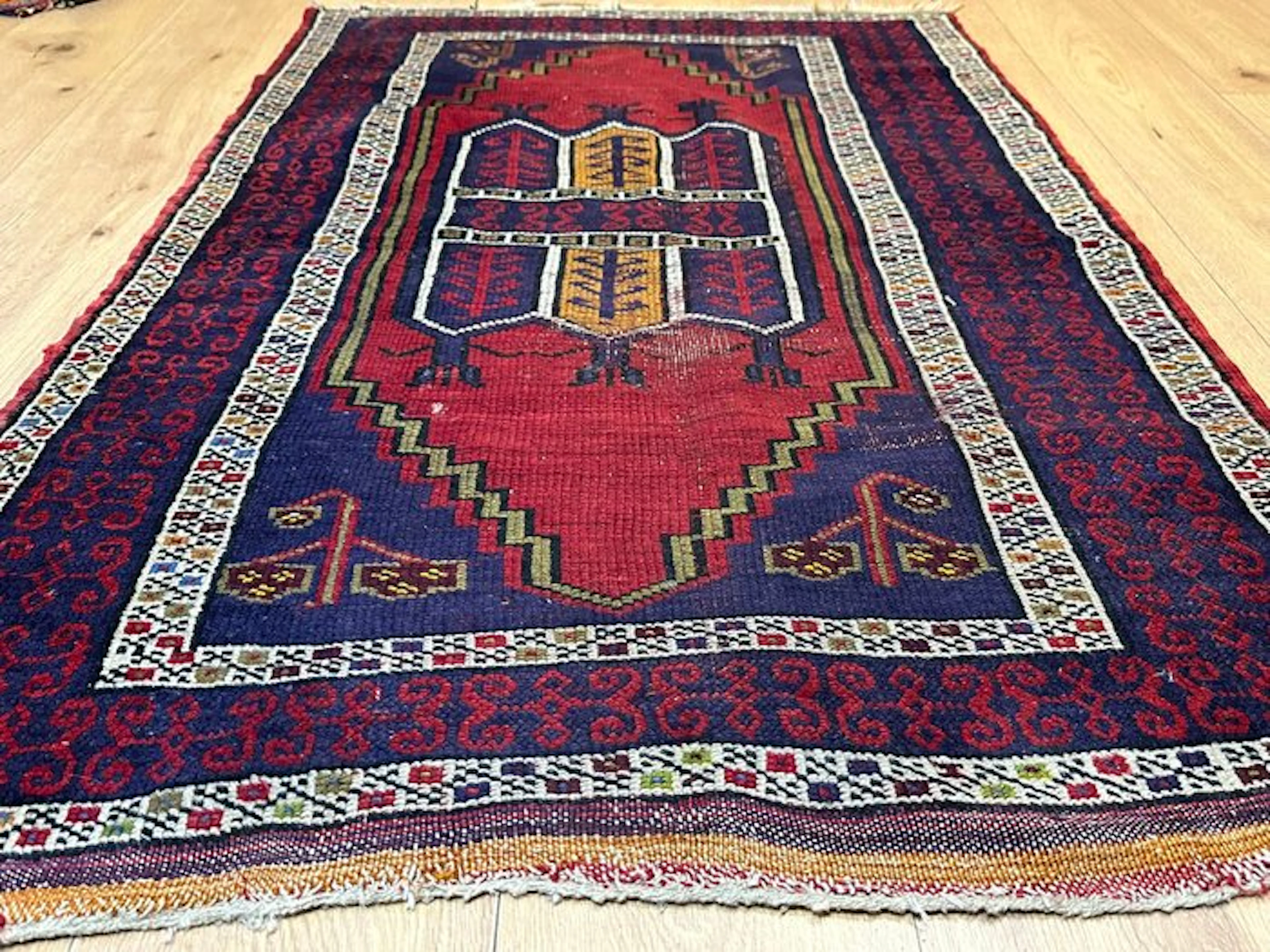 Antique Oriental rug with traditional tribal patterning...