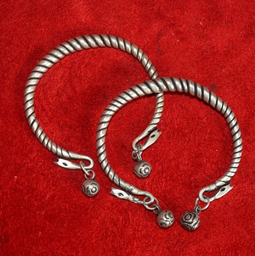 Pair of two twisted bracelets with charms