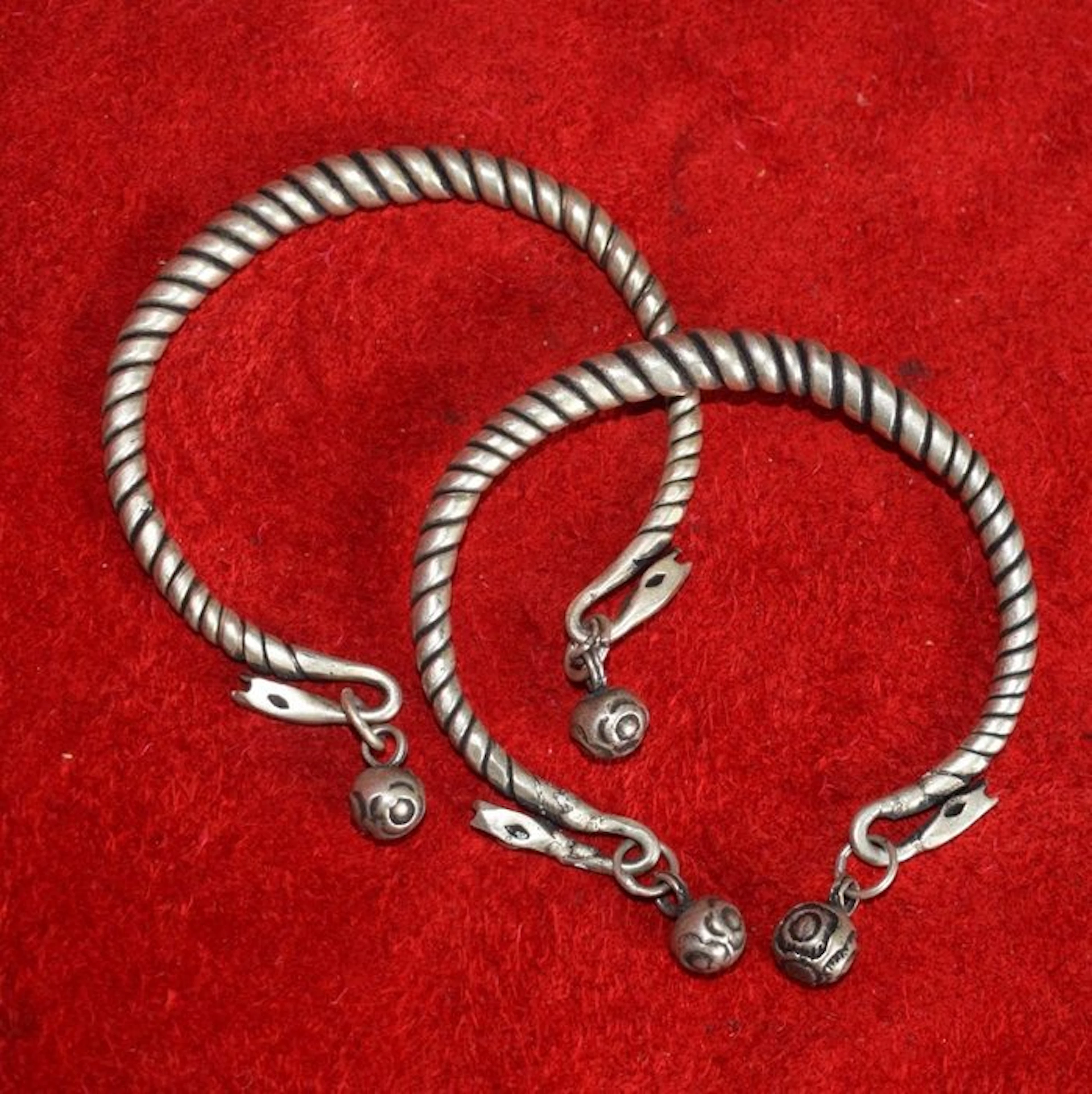 Pair of two twisted bracelets with charms