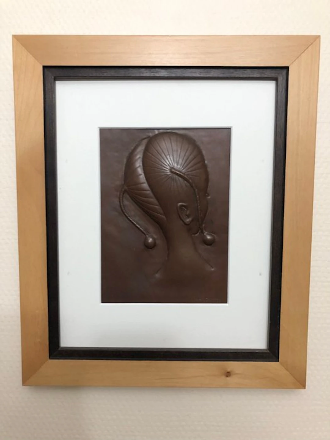 Repoussé copper - African girl with hair braided into circular patterns