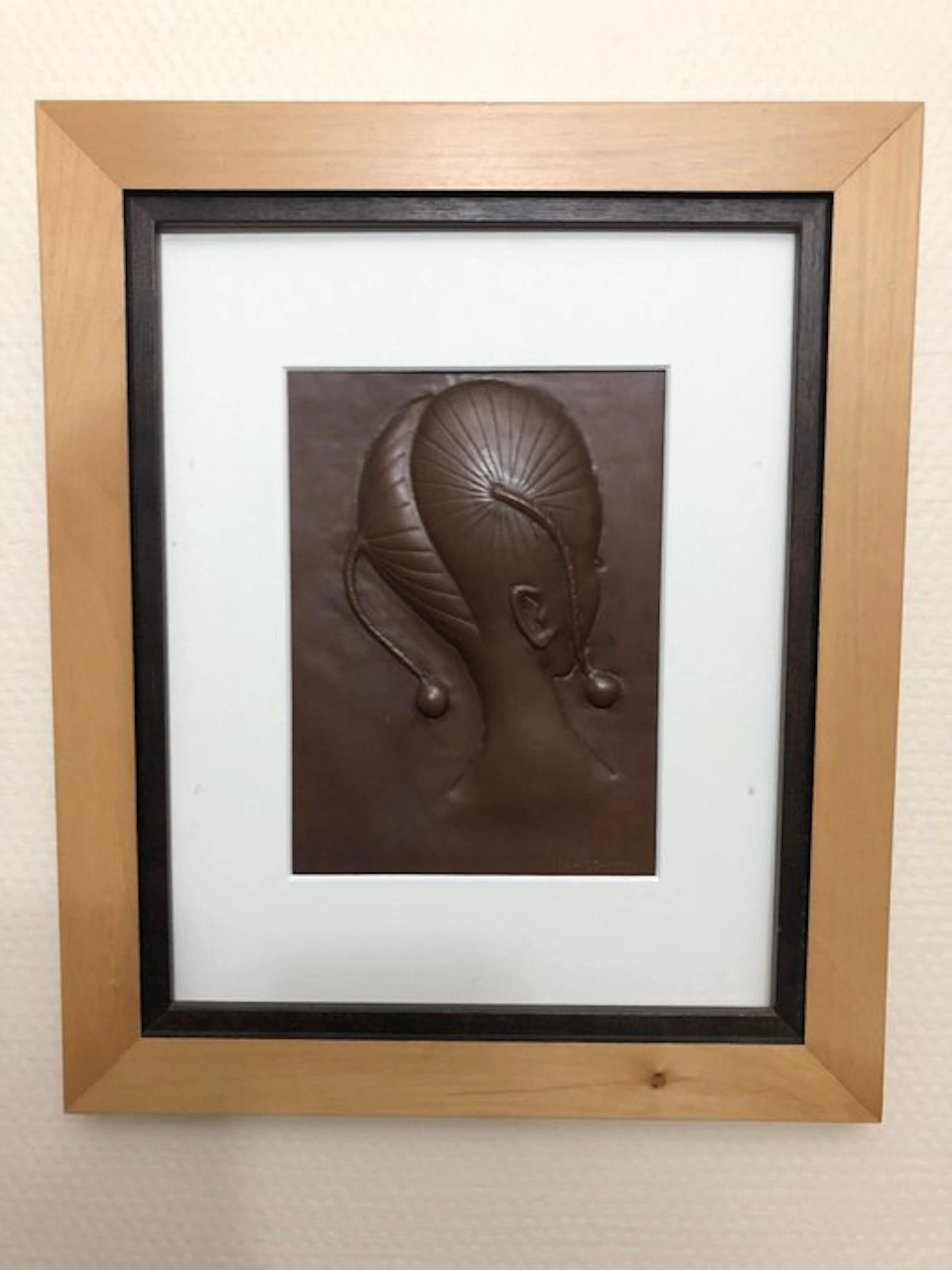 Repoussé copper - African girl with hair braided into circular patterns