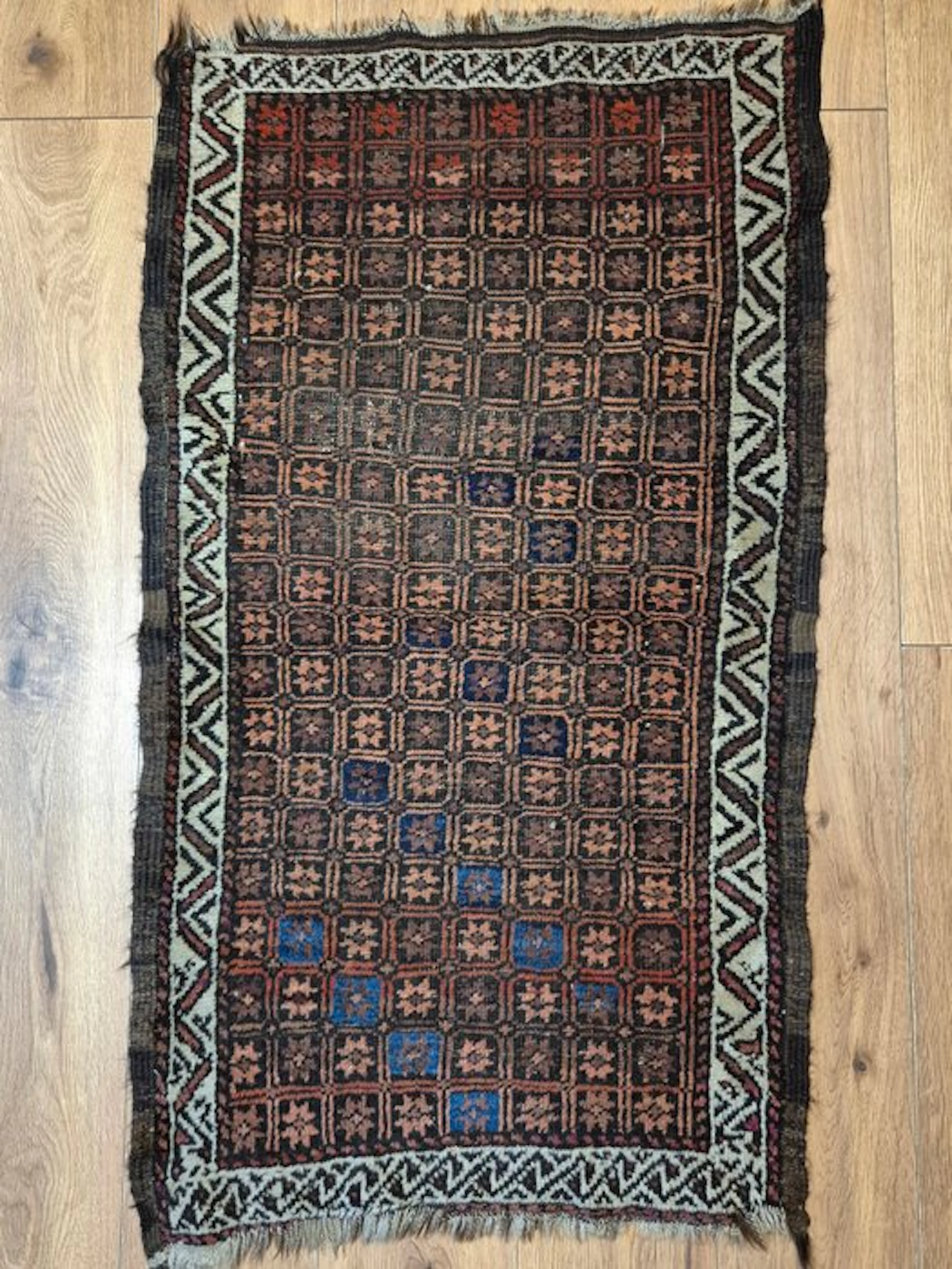 Antique Baluchi rug with a traditional shield motif and a...
