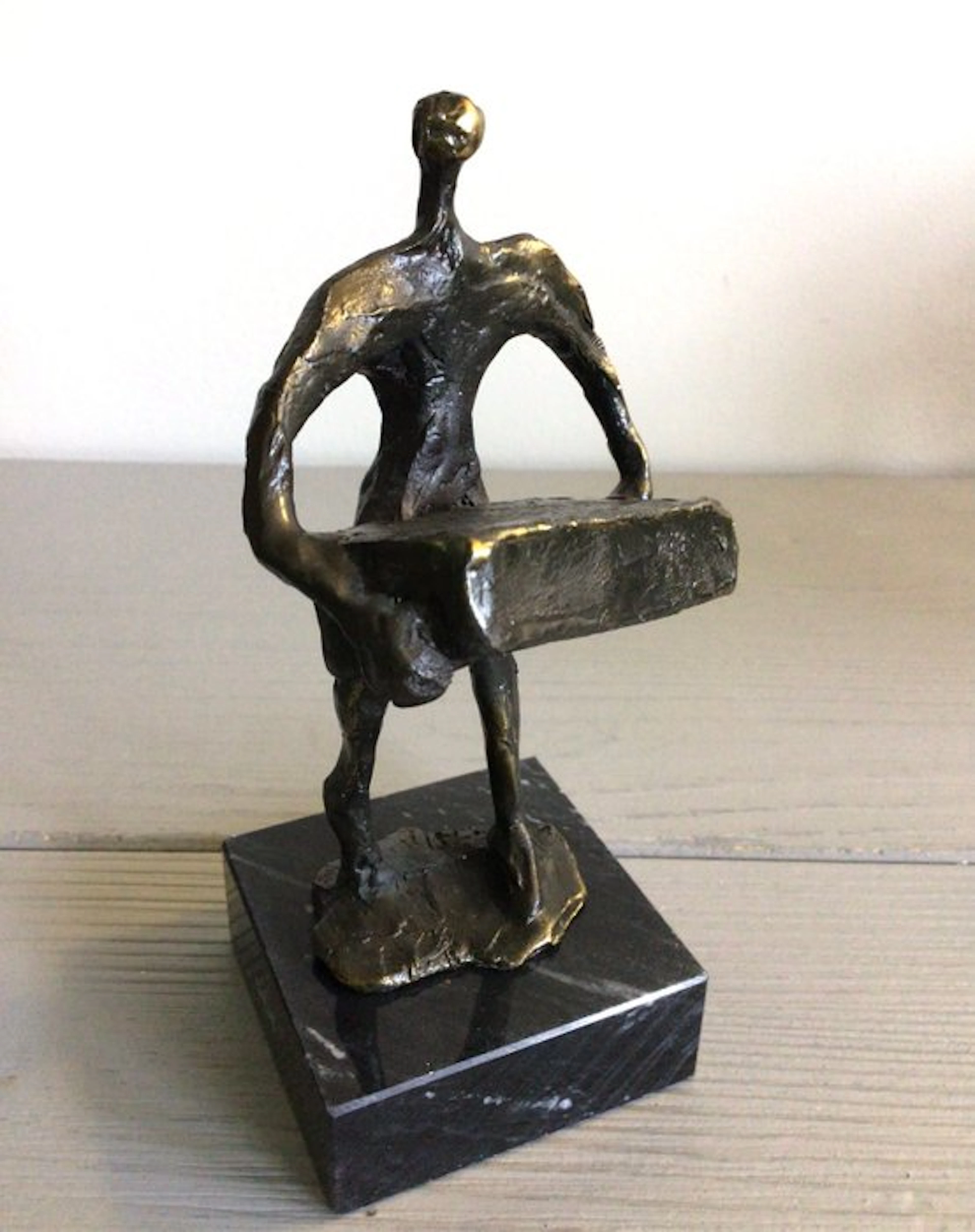 Corry Ammerlaan - Sculpture, “ De zware last dragen “ - 14 cm - patinated