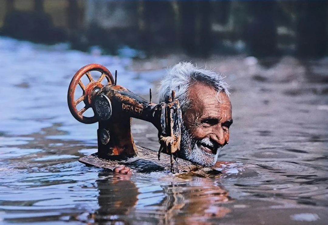Steve McCurry (1950–) - Tailor in monsoon floods in Porbandar. India, 1983