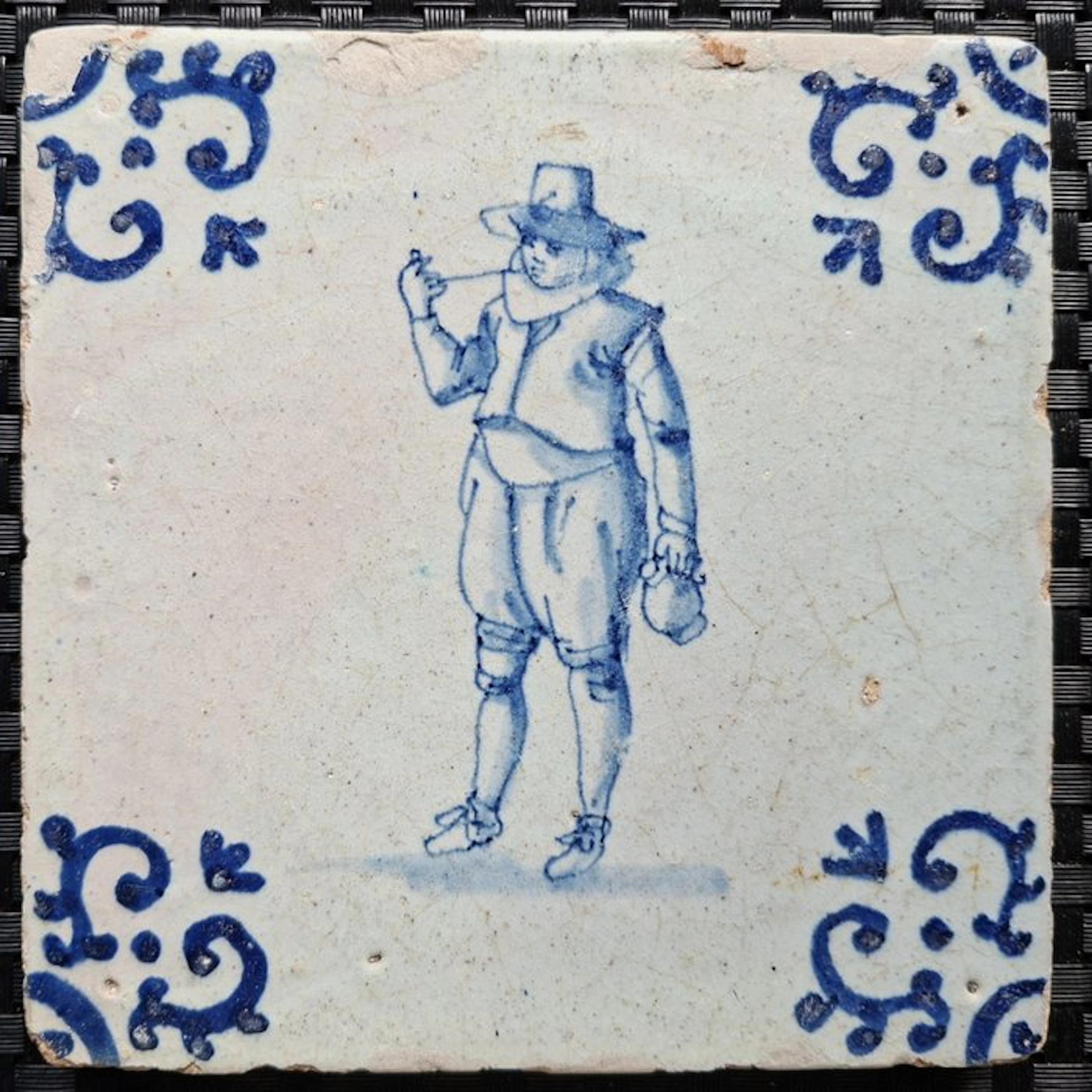 Tile - Antique tile depicting a pipe smoker and a jug. - 1600-1650