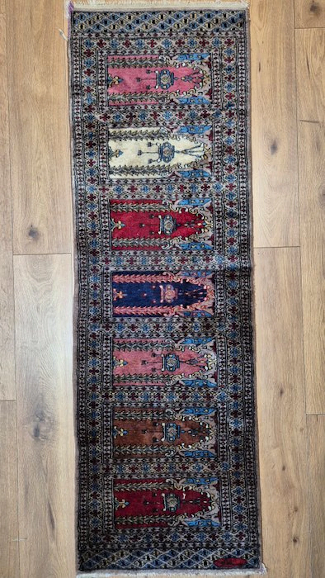 Fine signed Oriental rug in Bokhara style with a row of mihrab motifs