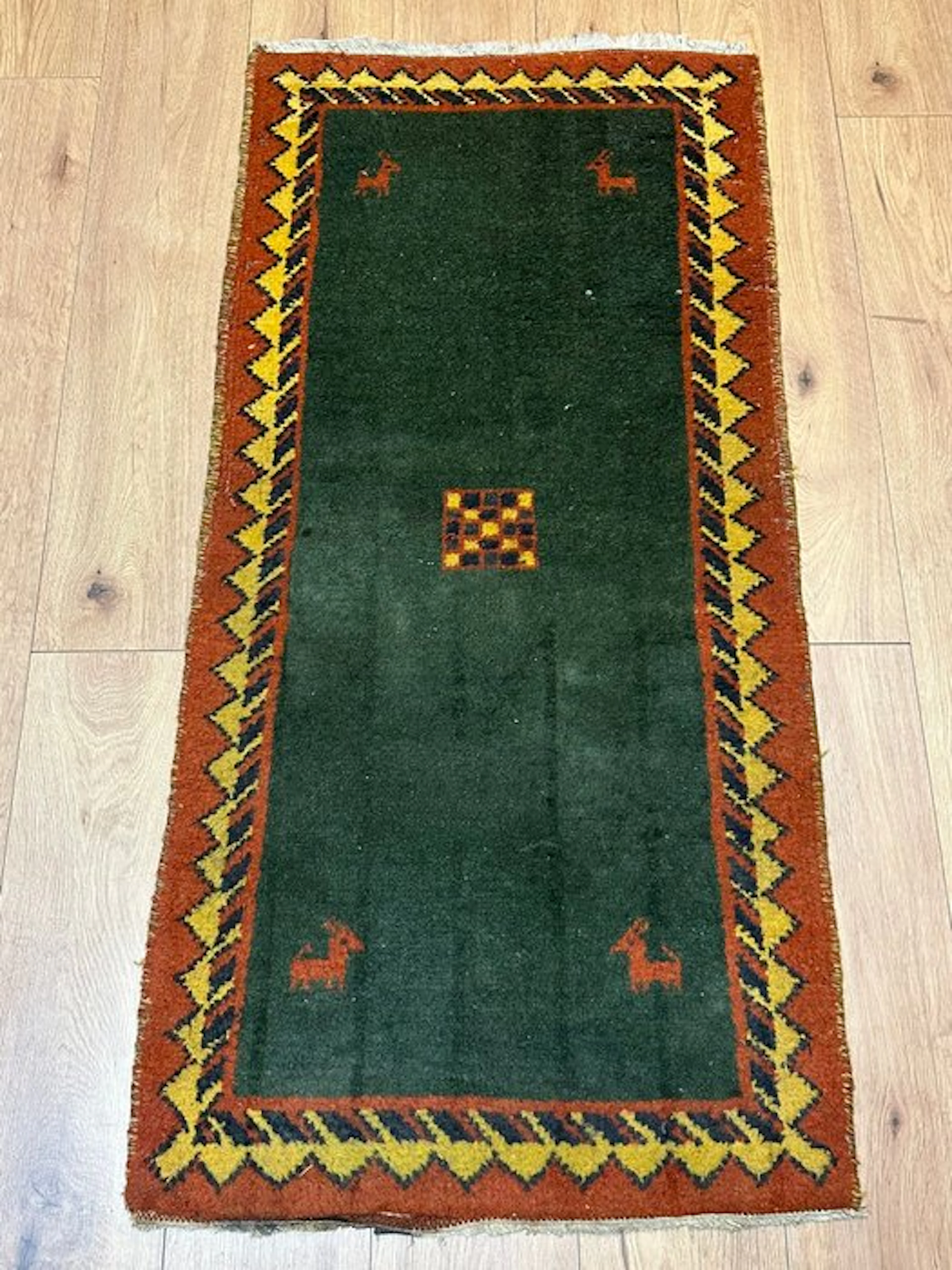 Beautiful Gabbeh runner with a deep green field and animal motifs
