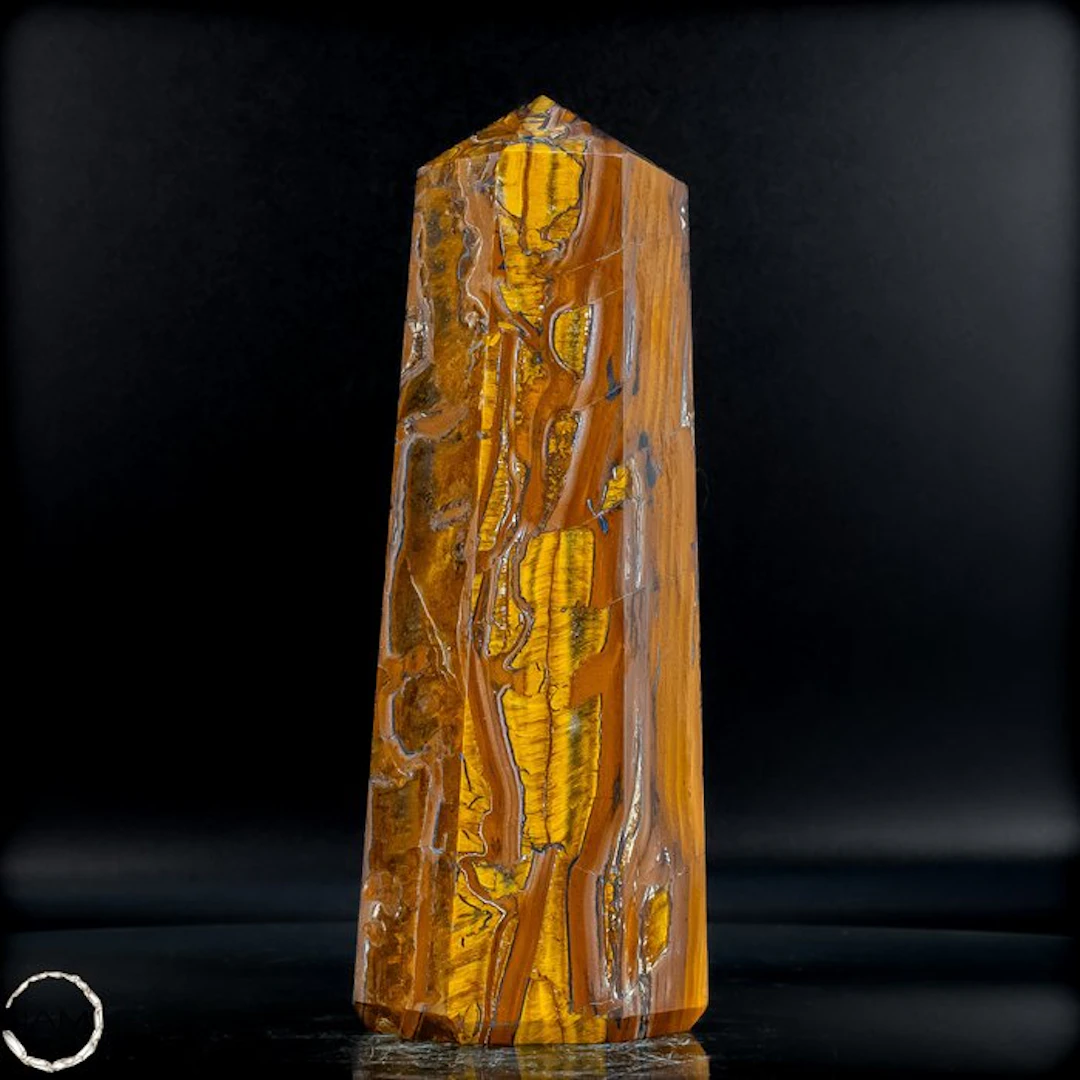 Natural tiger's-eye obelisk with a golden-brown silky texture.- 1131.39 g