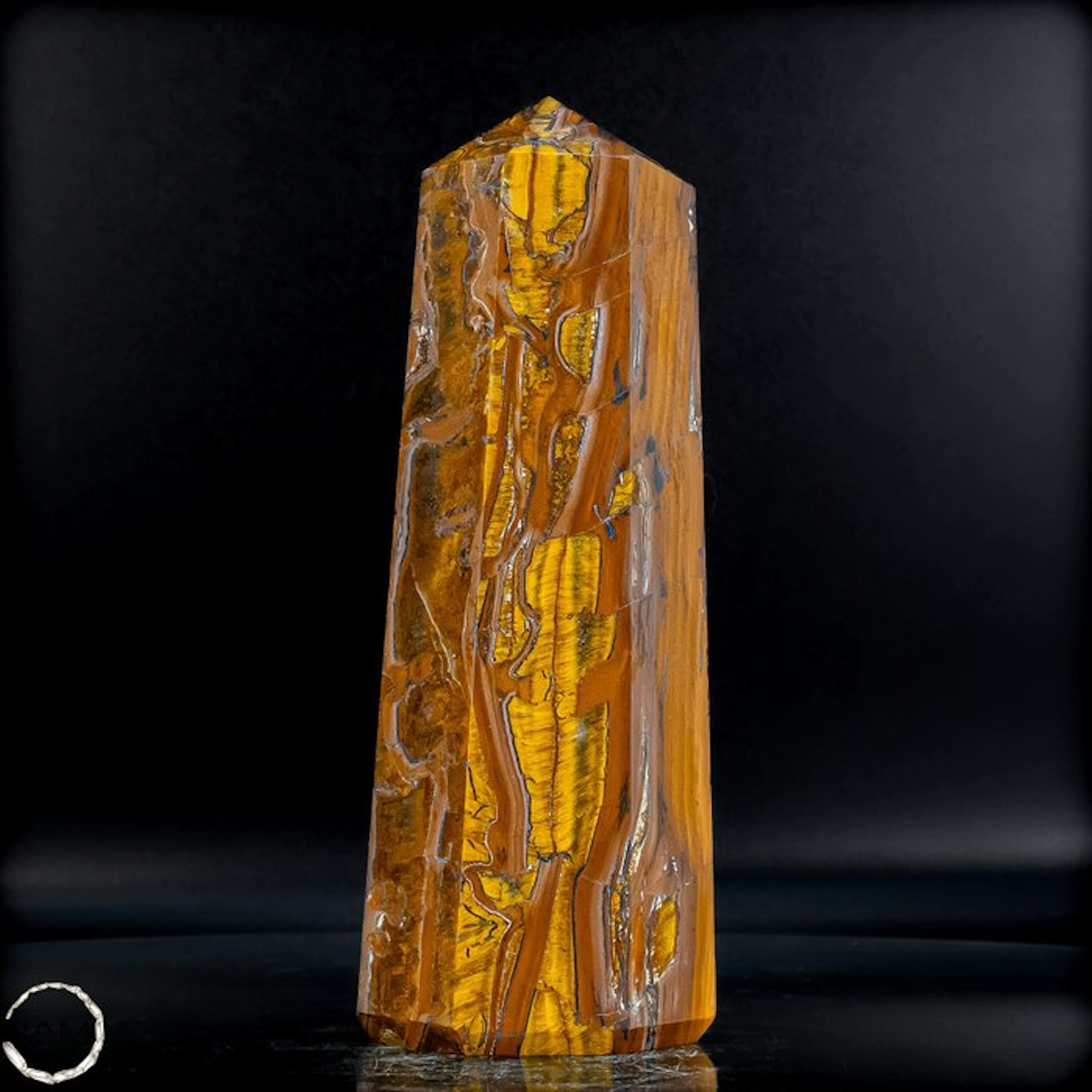Natural tiger's-eye obelisk with a golden-brown silky texture.- 1131.39 g