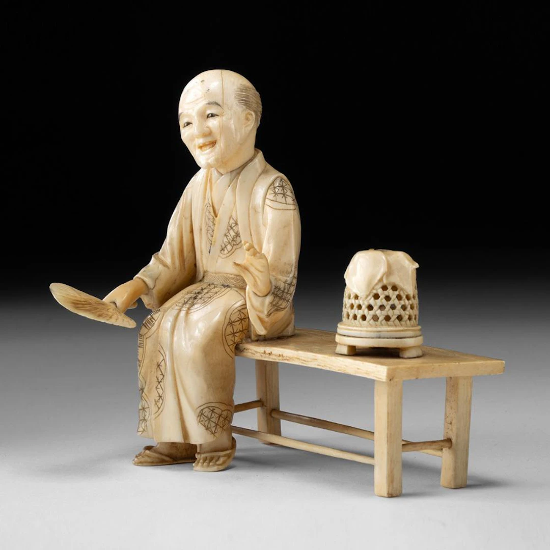 Meiji Japanese Ivory Okimono, Elder on Bench with Fan and Bird Cage