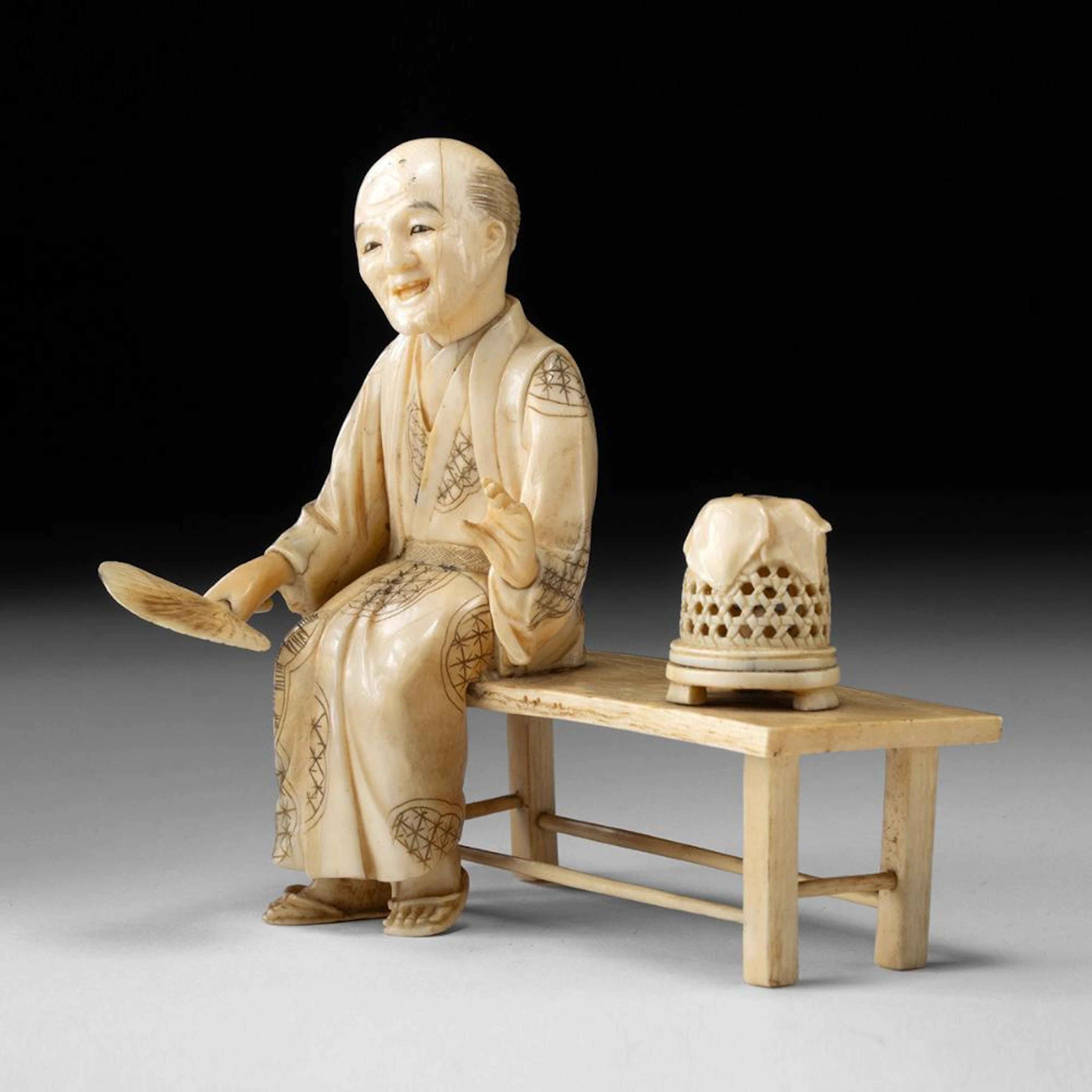 Meiji Japanese Ivory Okimono, Elder on Bench with Fan and Bird Cage