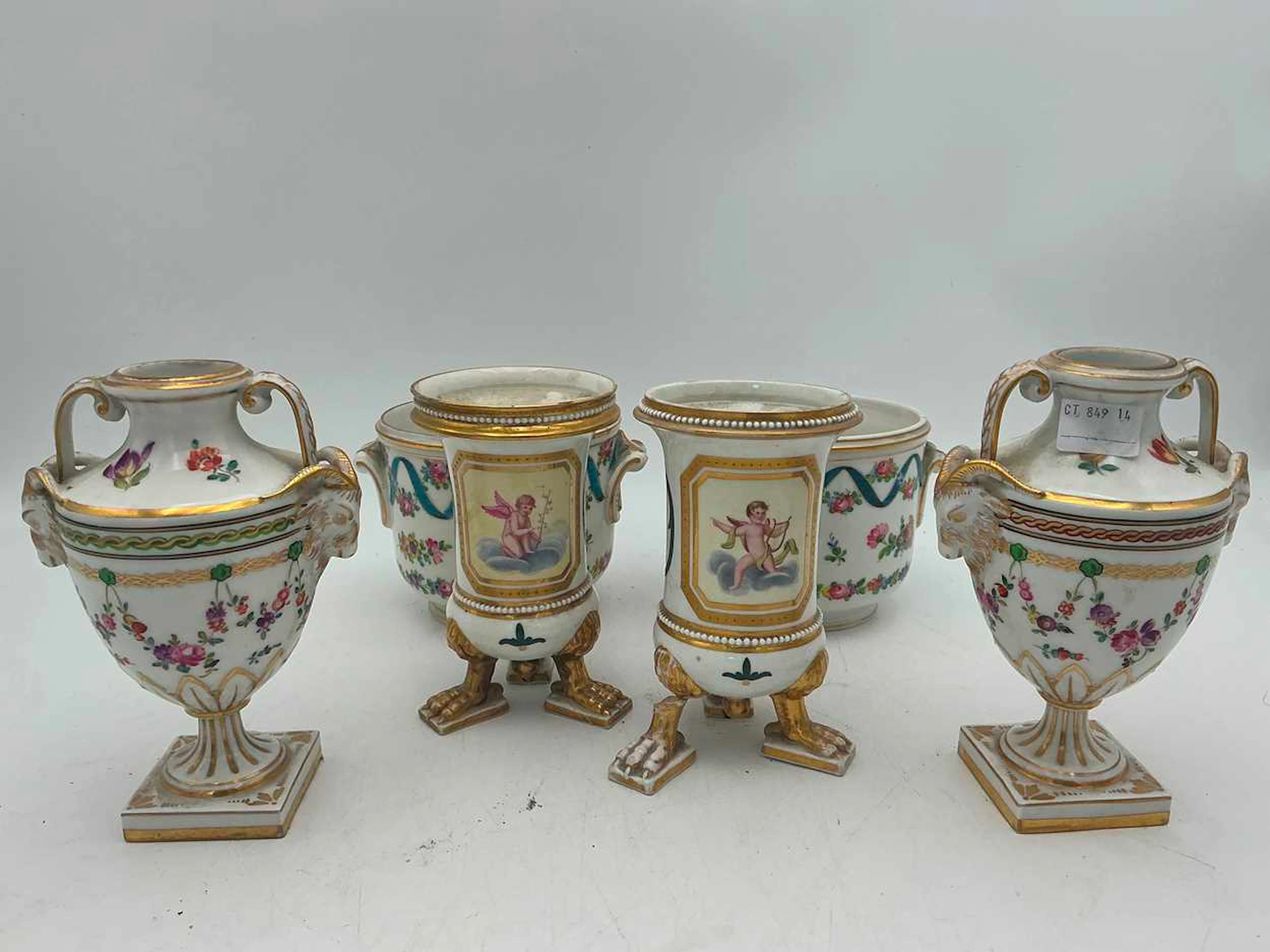 A pair of porcelain neo-classical style urns with rams head handles