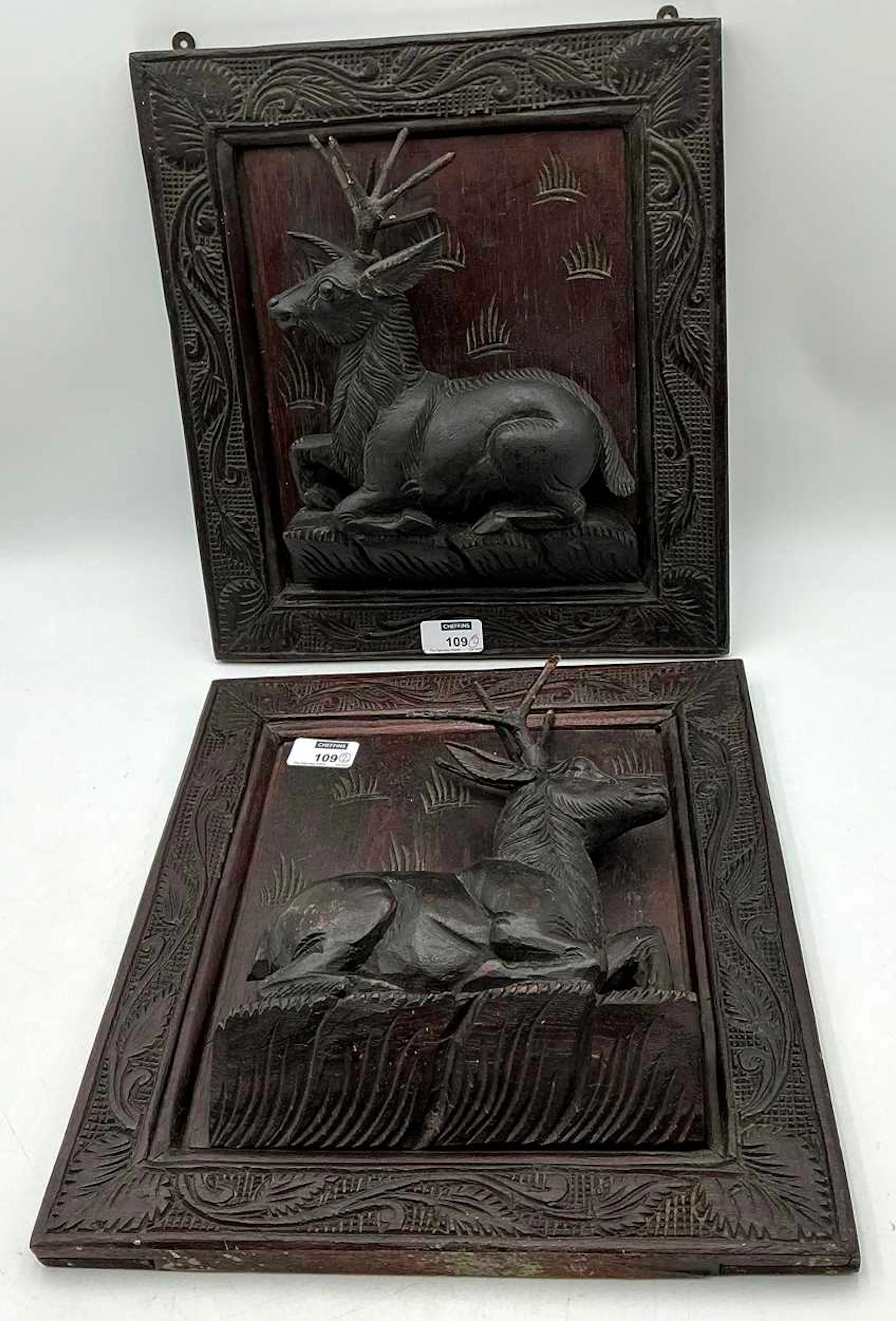 A pair of Black Forest carved panels with resting deer