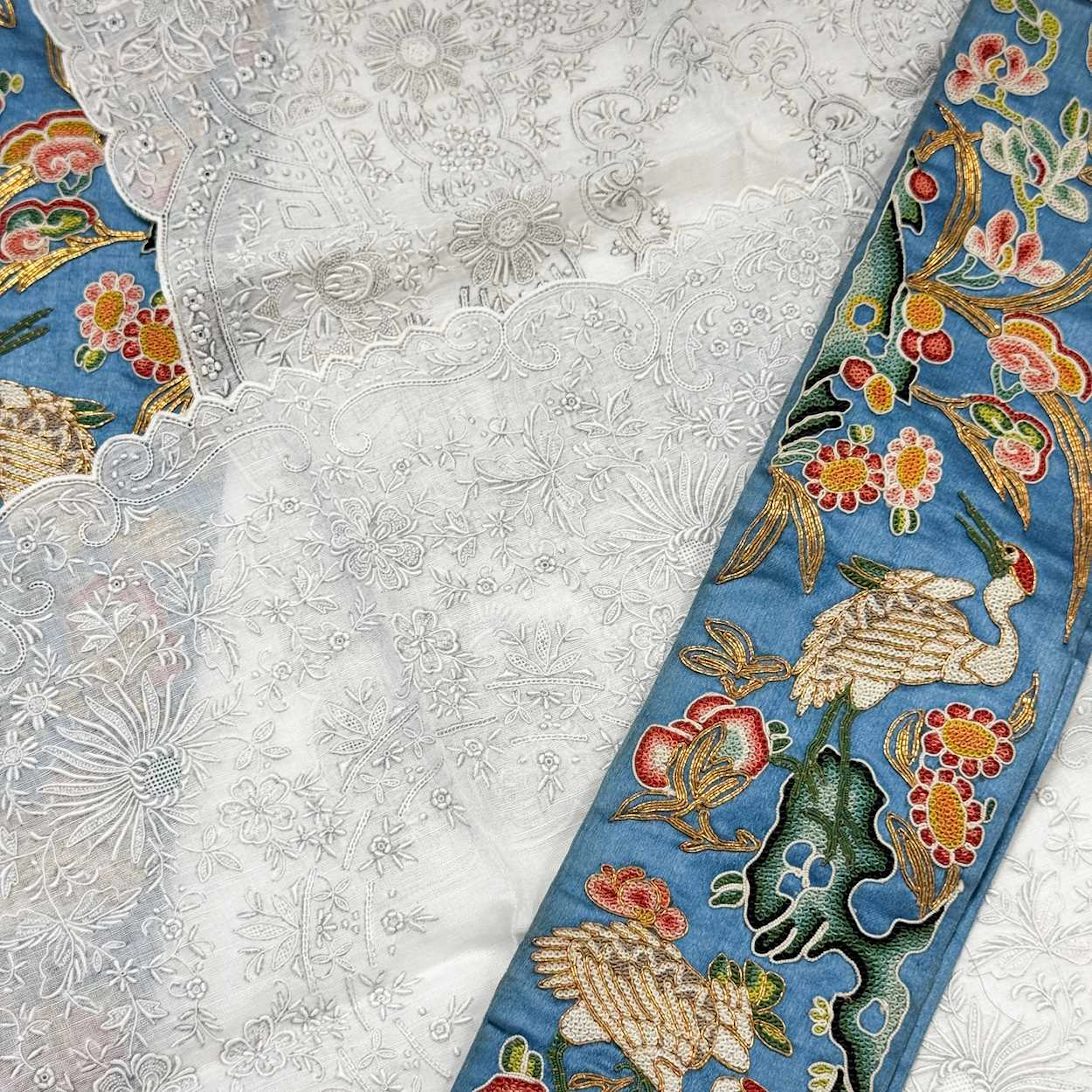 A pair of Chinese light blue silk and forbidden stitch embellished