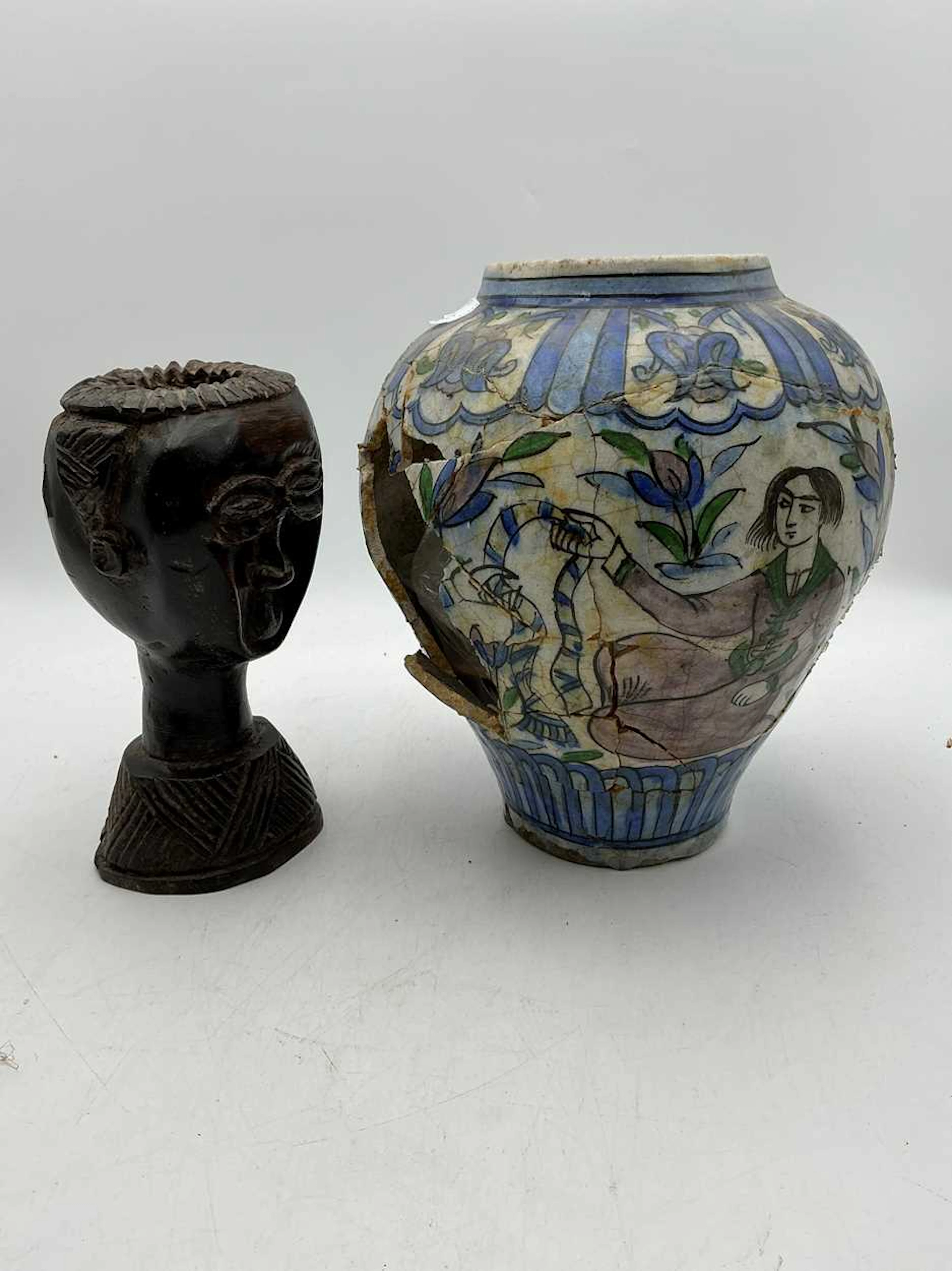 A damaged Persian vase painted with seated figures...