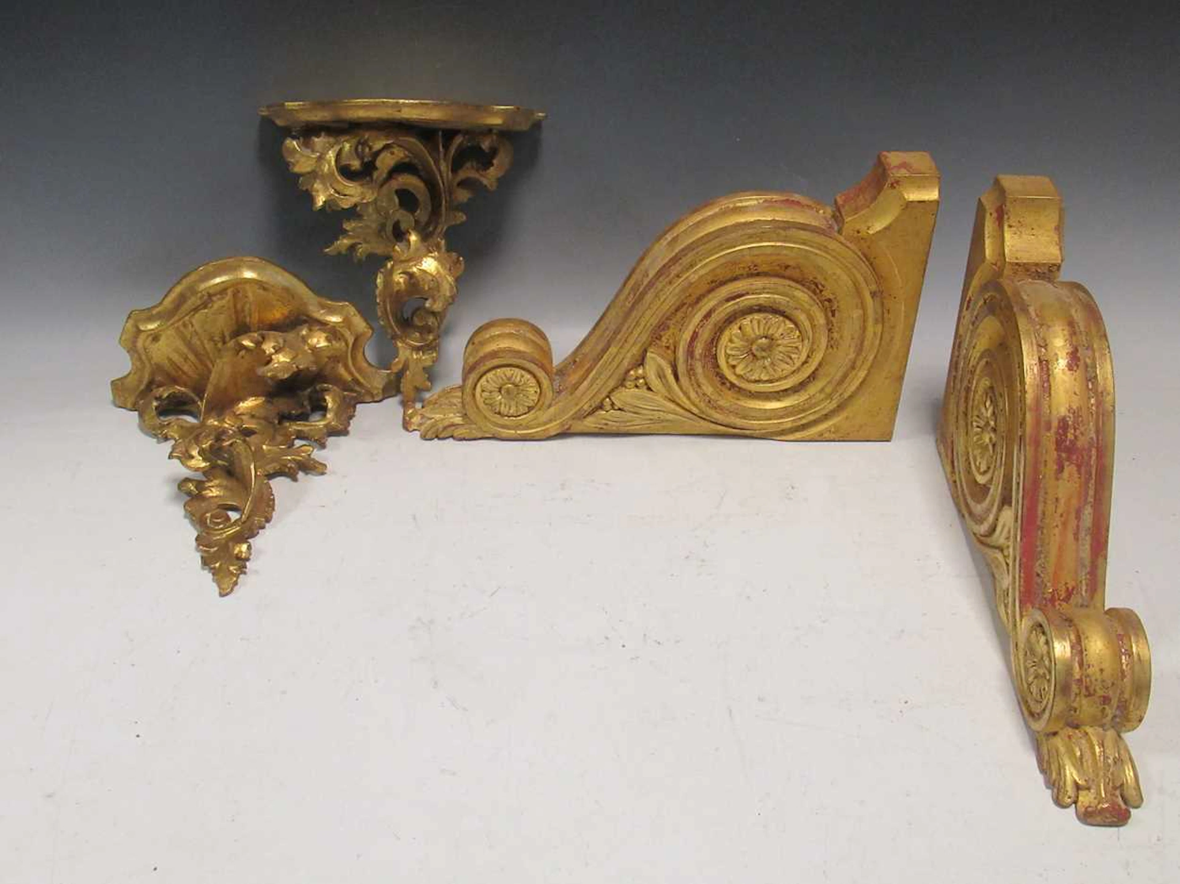 A pair of rococo style gilt painted wall brackets