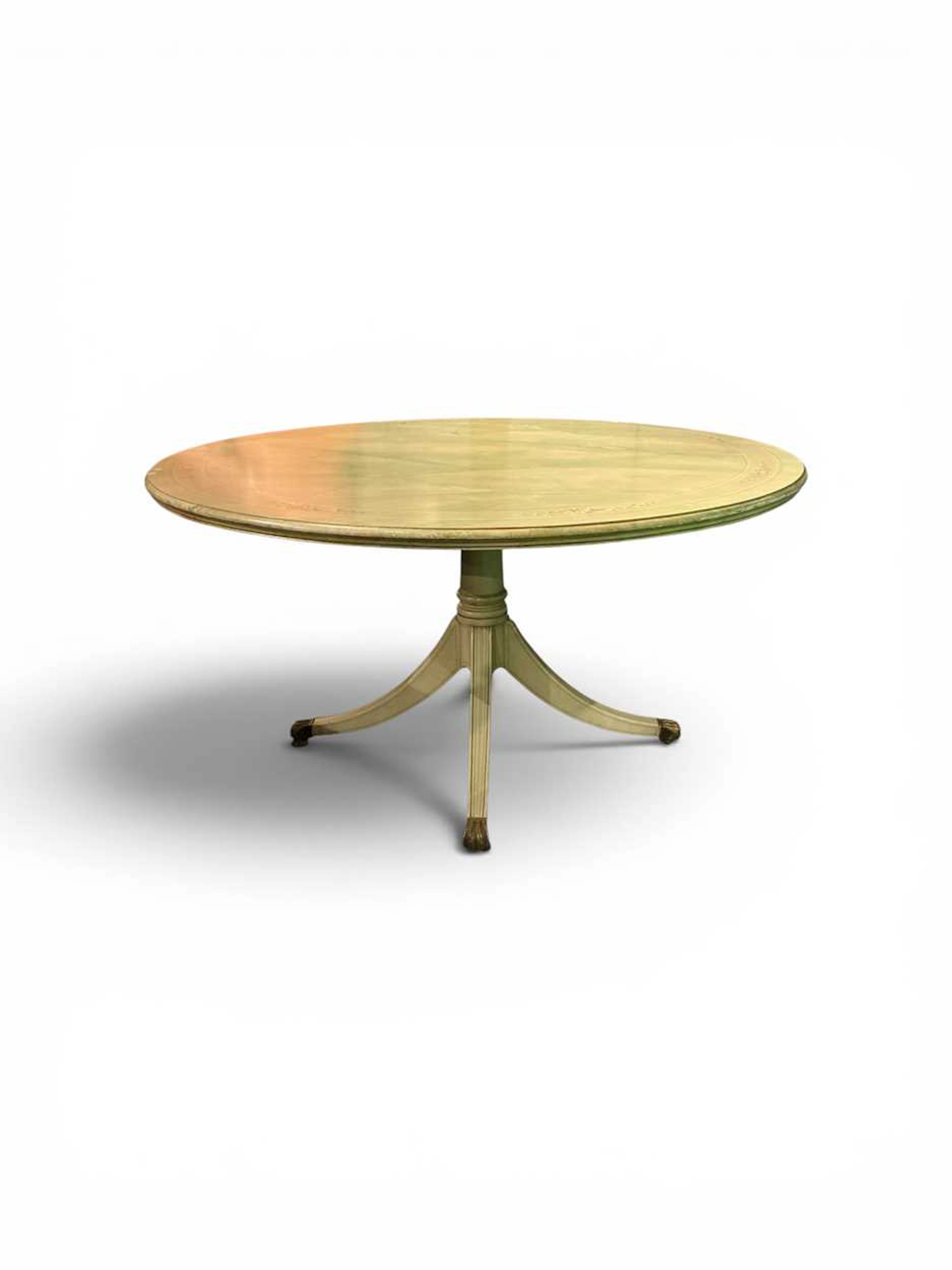 A circular breakfast table with quatre-form base on sabre legs