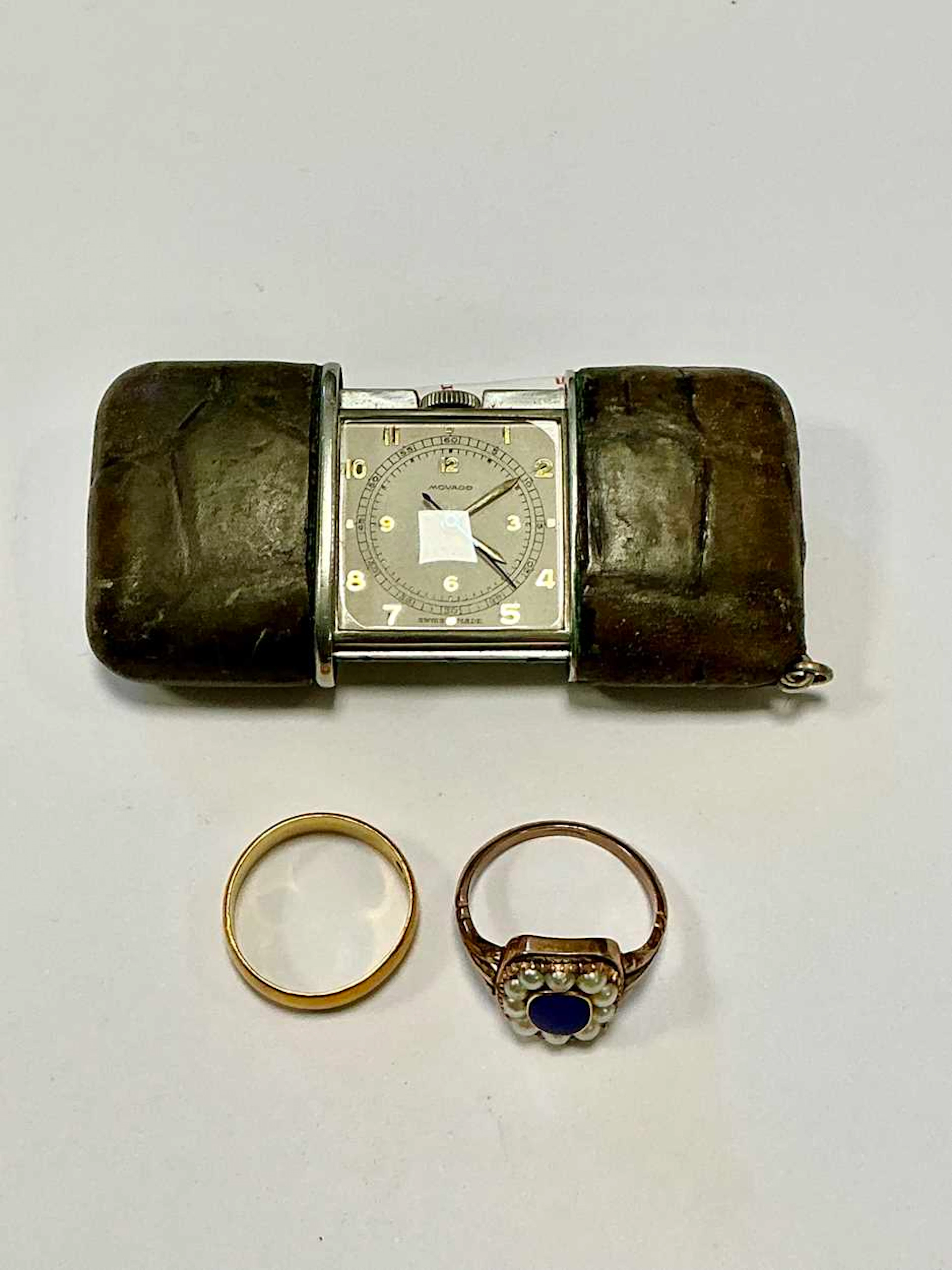 A Movado travel clock together with a hallmarked 22ct gold wedding band