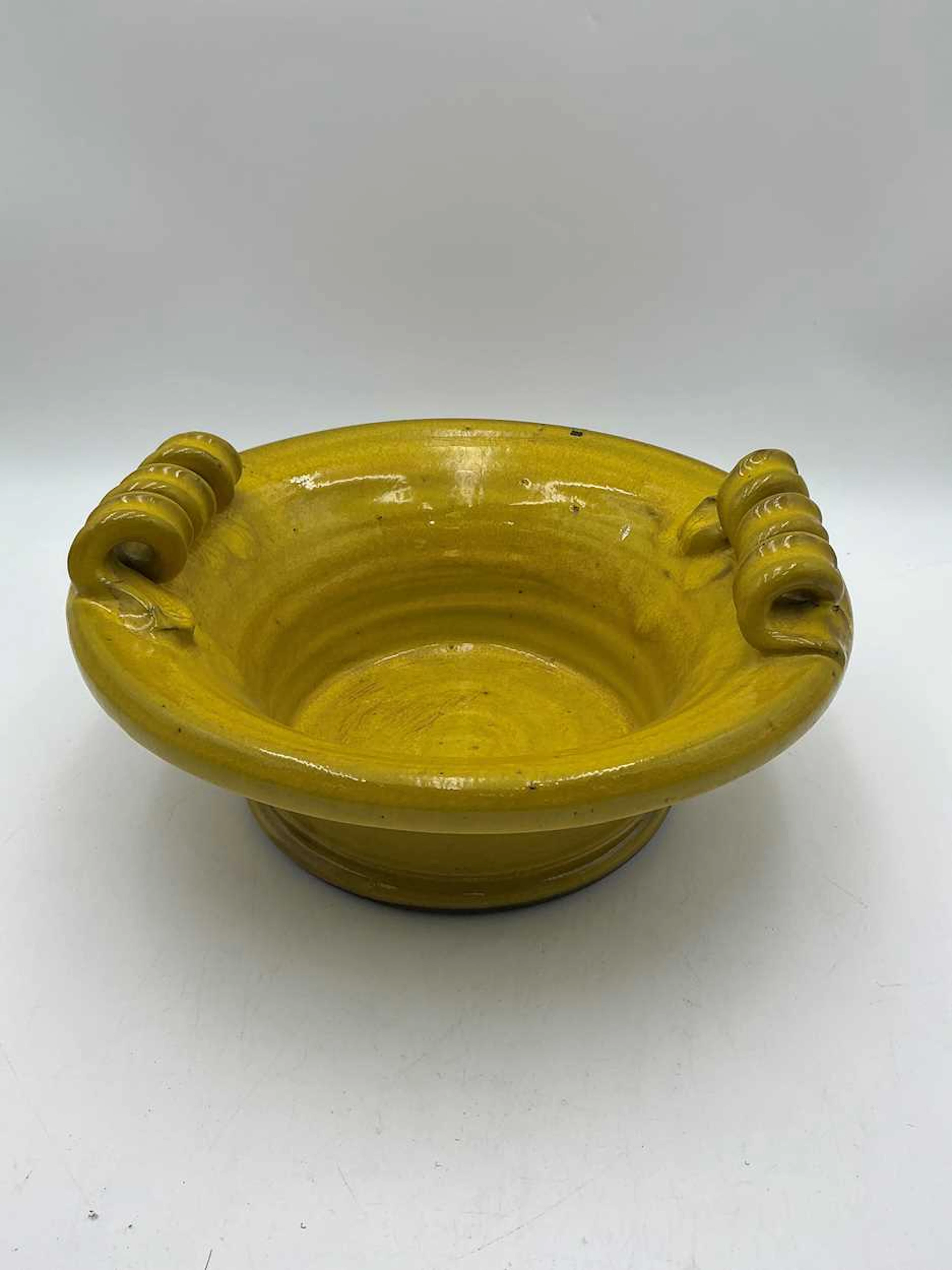 Yellow glazed pottery jardiniere with tendril handle detail