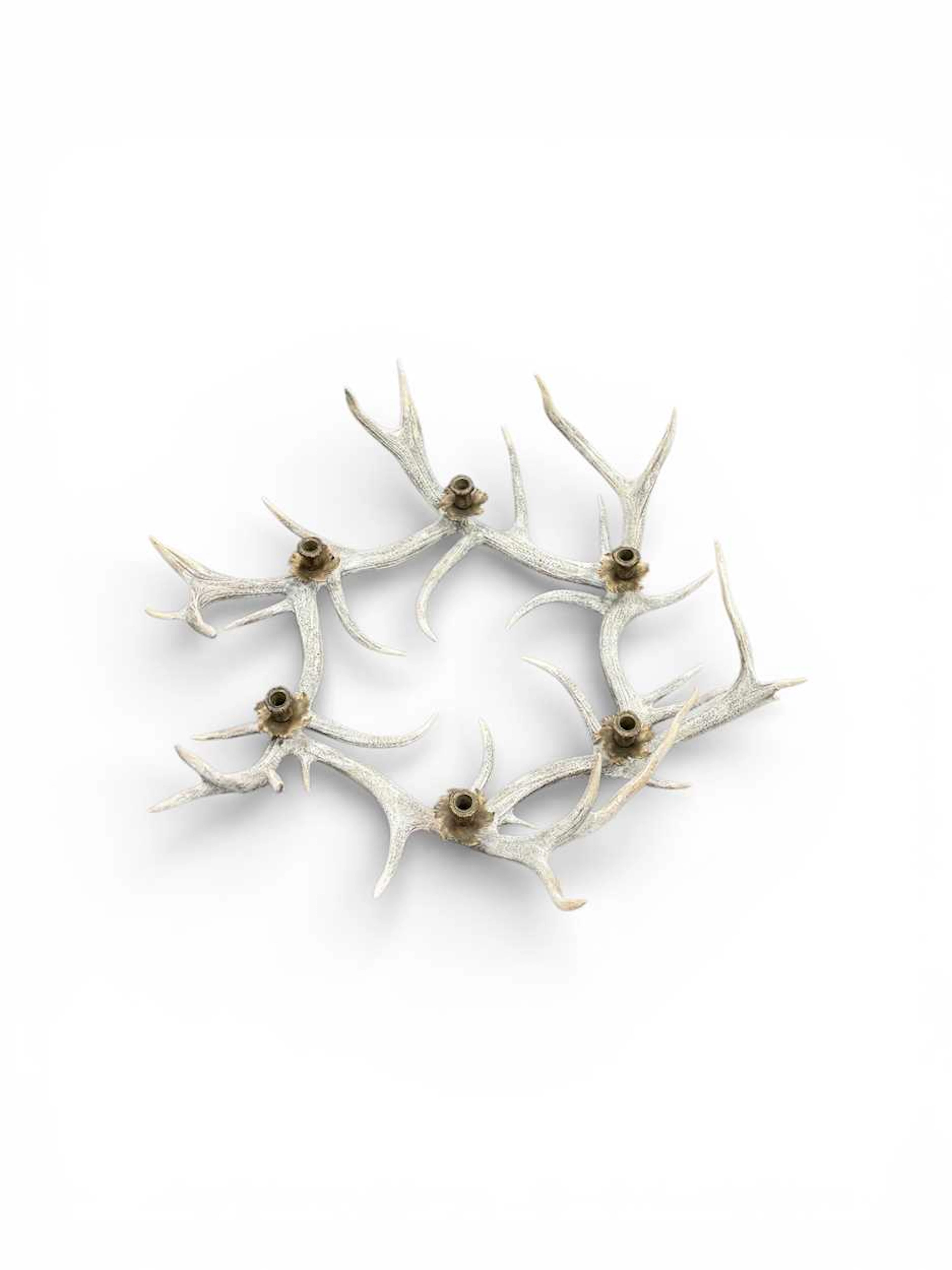 A white washed resin antler chandelier with six brass sconces