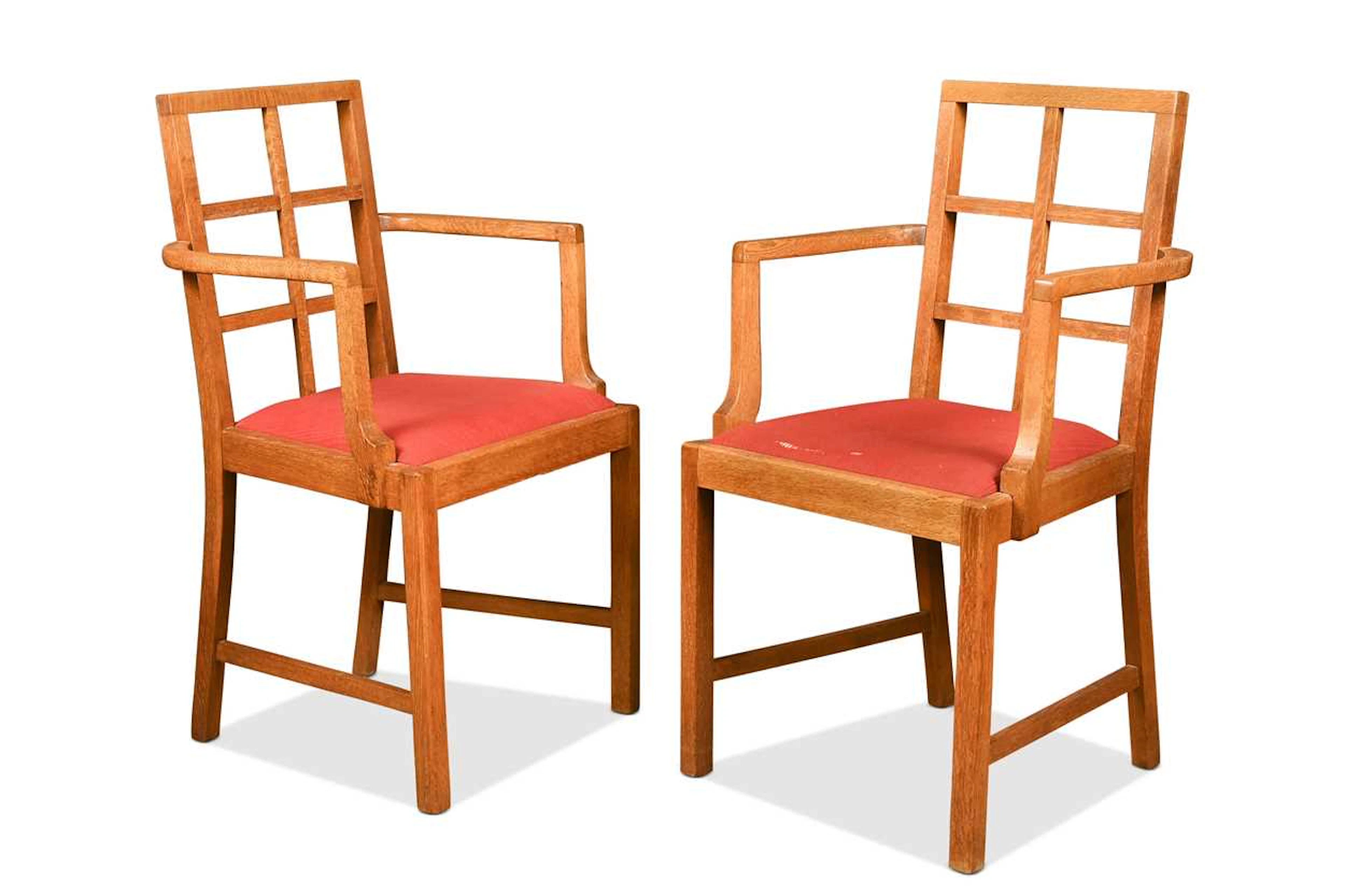 In the manner of Heal's, a pair of oak lattice back elbow chairs, circa 1930