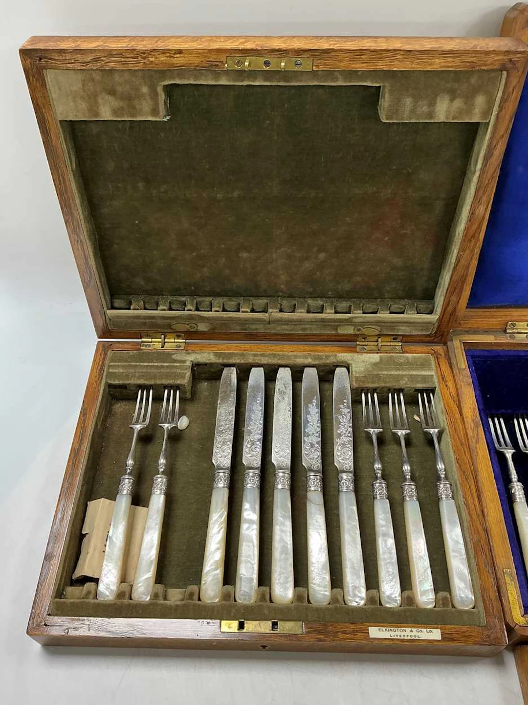 Two oak boxes containing mother of pearl and silver desert knives & forks