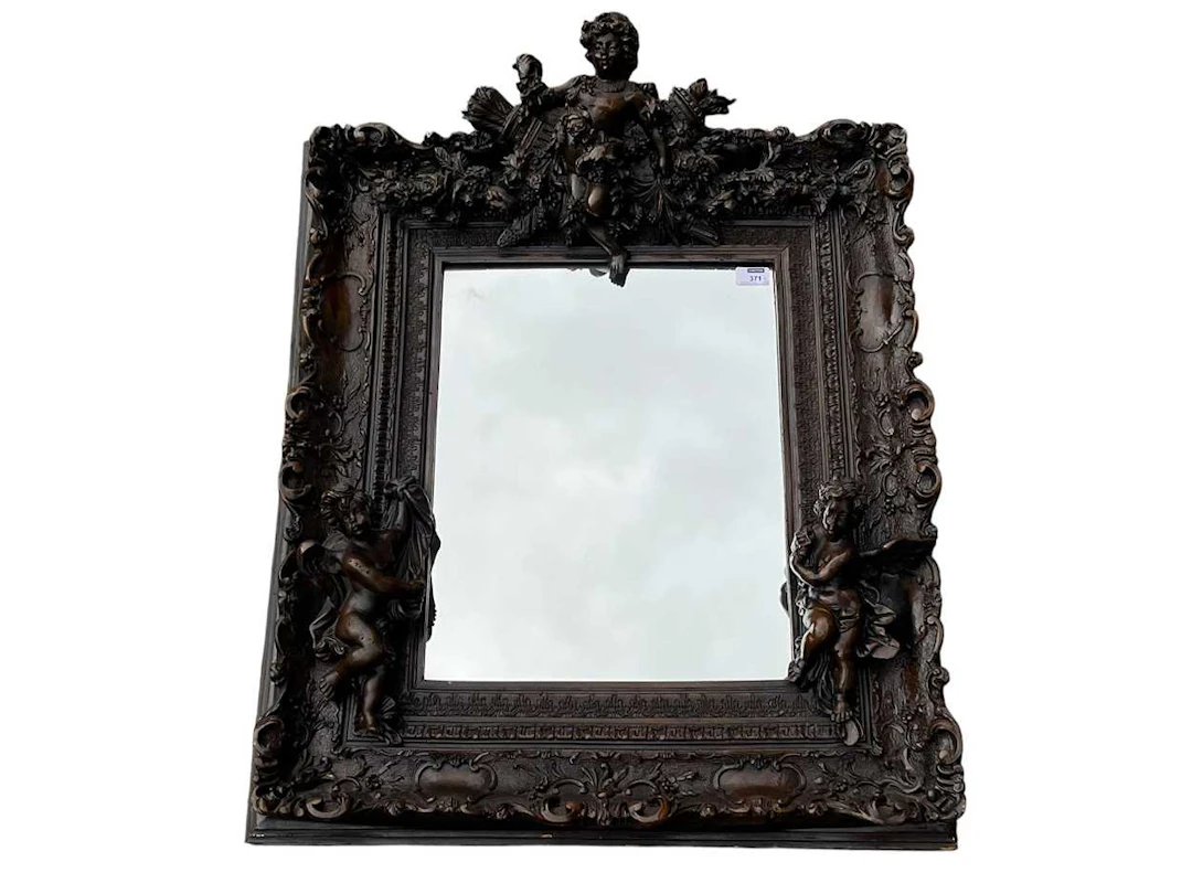 A carved and composition mirror with decorative putti 34...