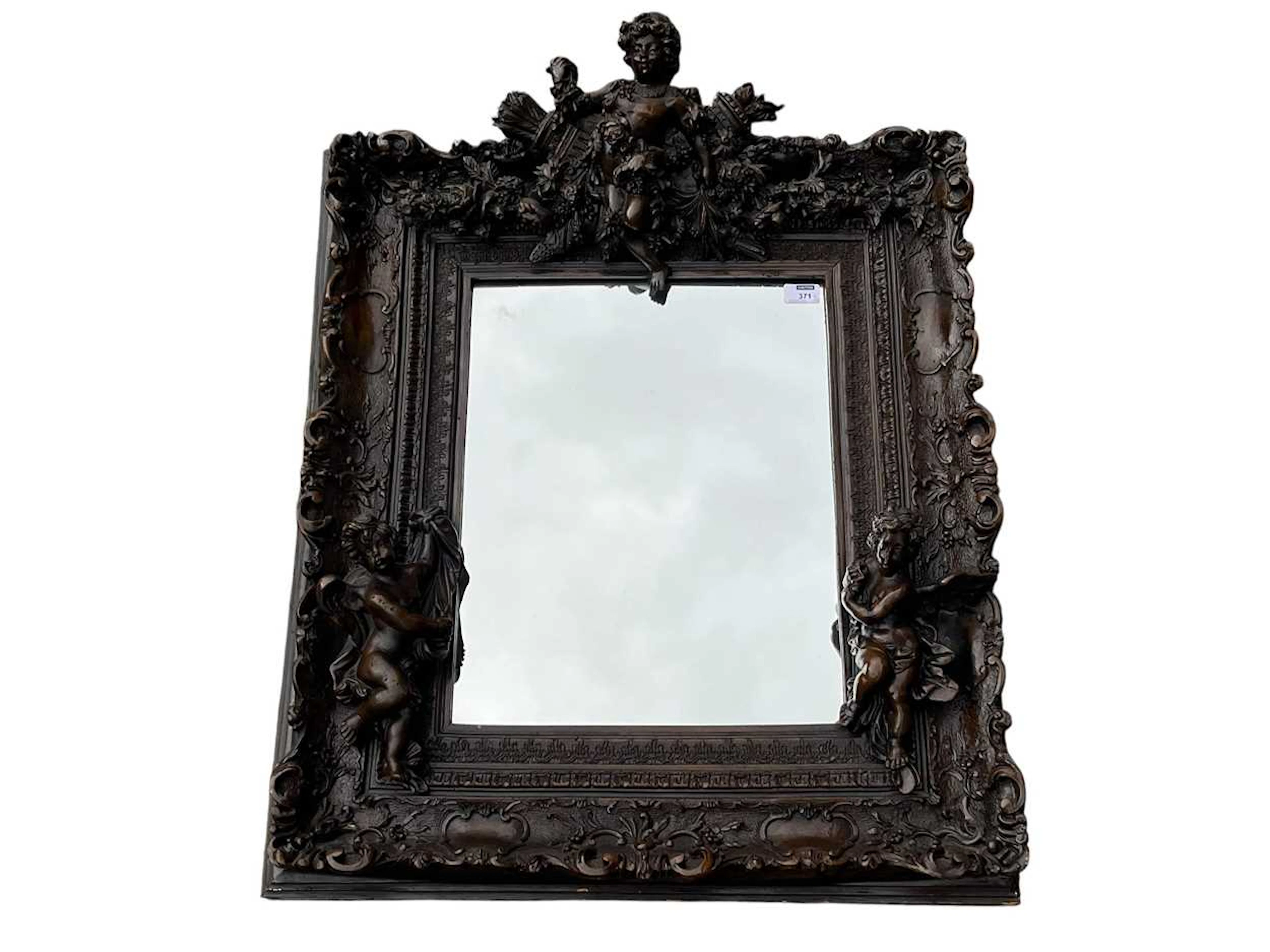 A carved and composition mirror with decorative putti 34...