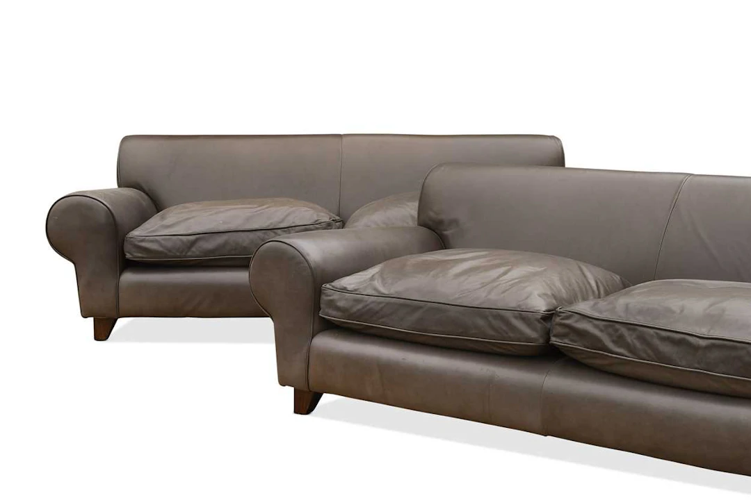 A pair of large brown leather 'Bertie' sofas, retailed by Liberty & Co.