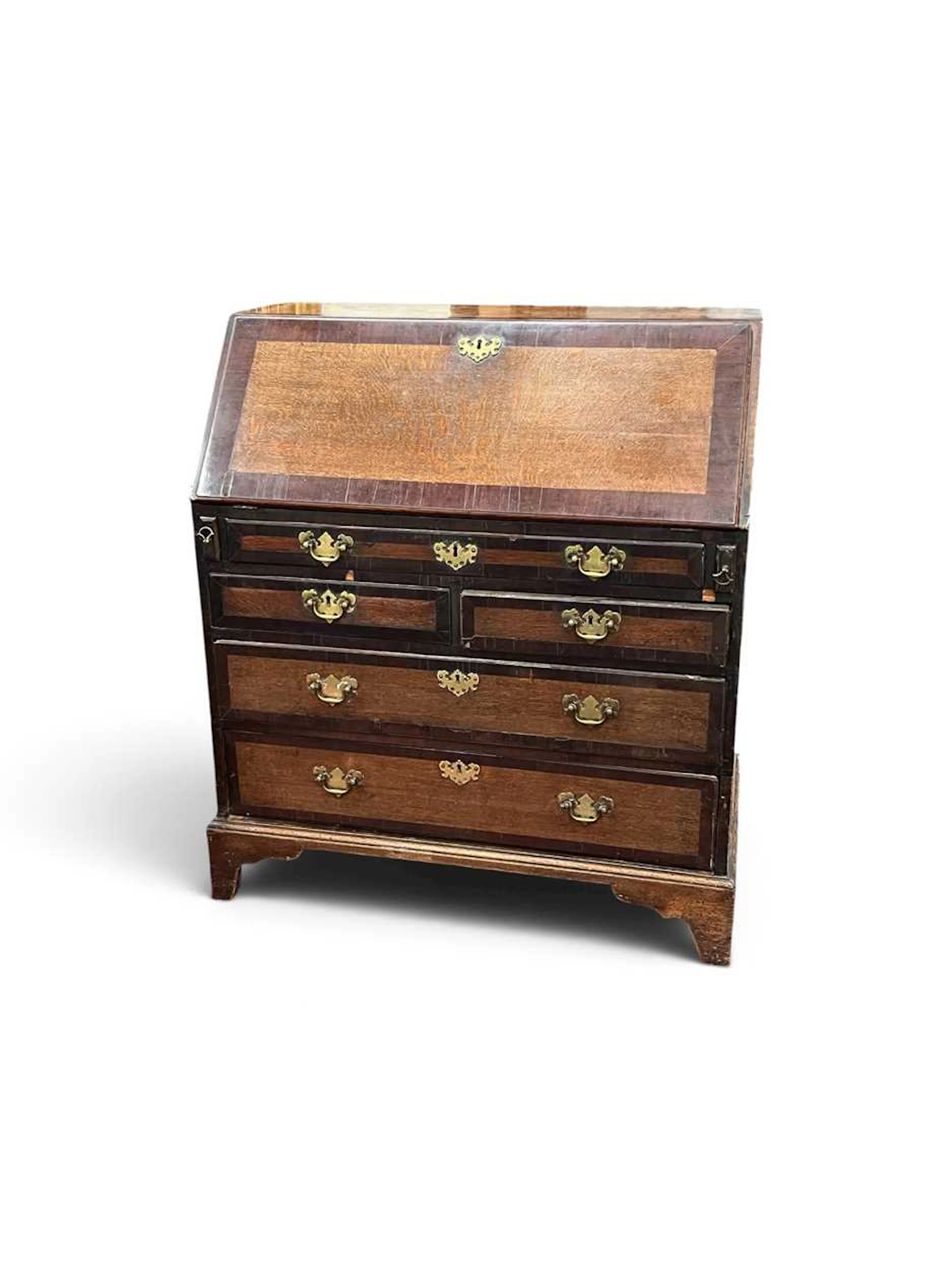 An oak and mahogany crossbanded bureau