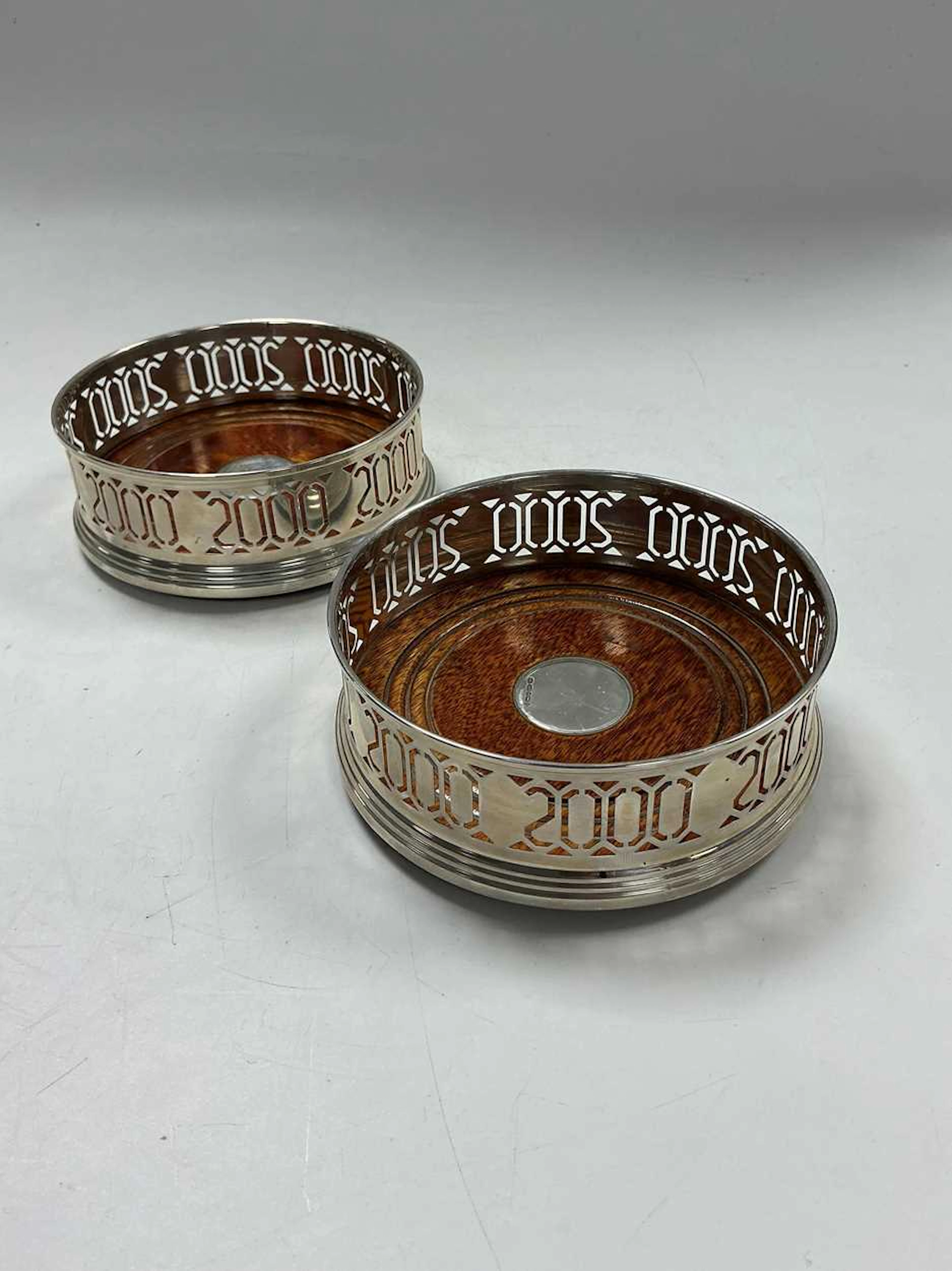 A pair of modern silver wine coasters
