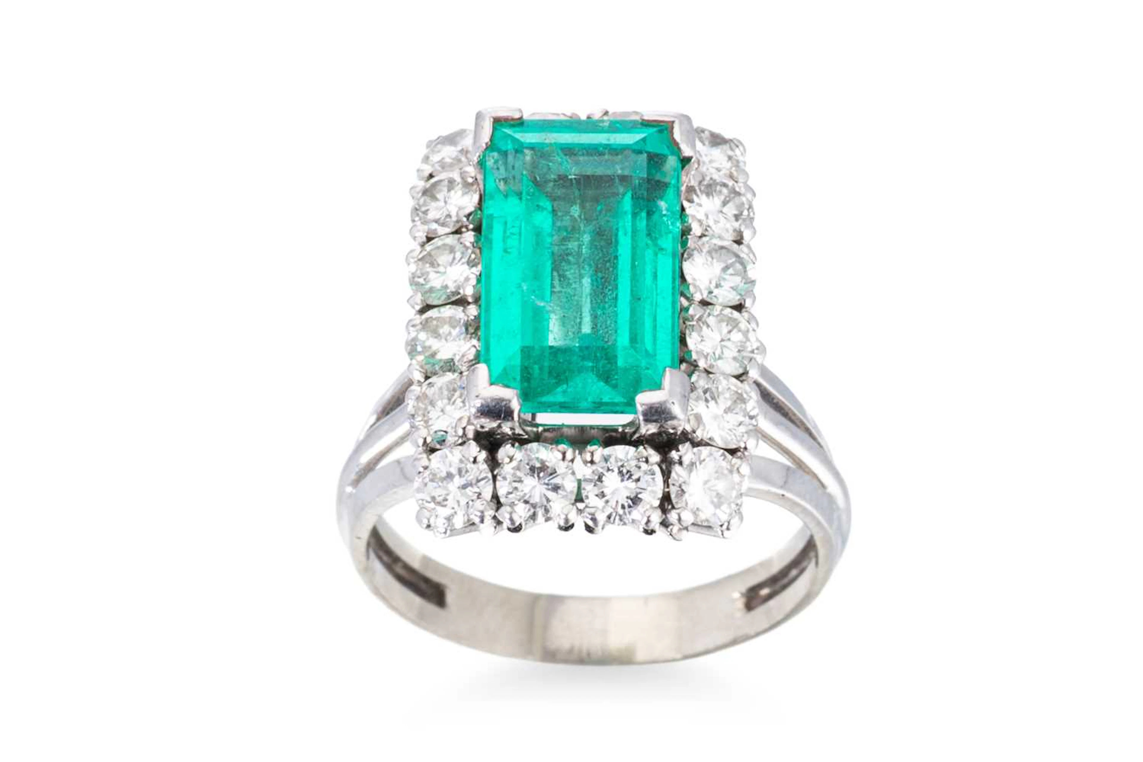 AN EMERALD AND DIAMOND CLUSTER RING