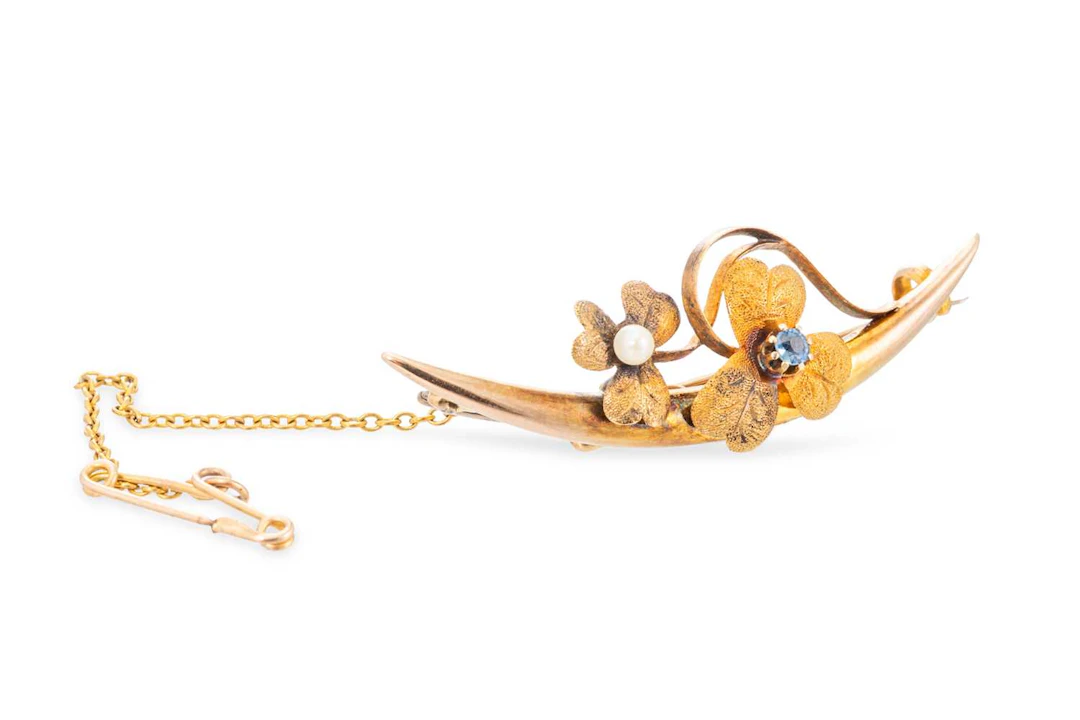 AN ANTIQUE 15CT GOLD CRESCENT BROOCH