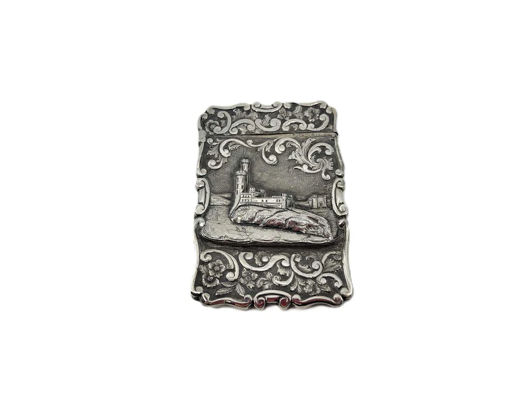 AN ANTIQUE VICTORIAN STERLING SILVER EMBOSSED 'CASTLE' CARD CASE