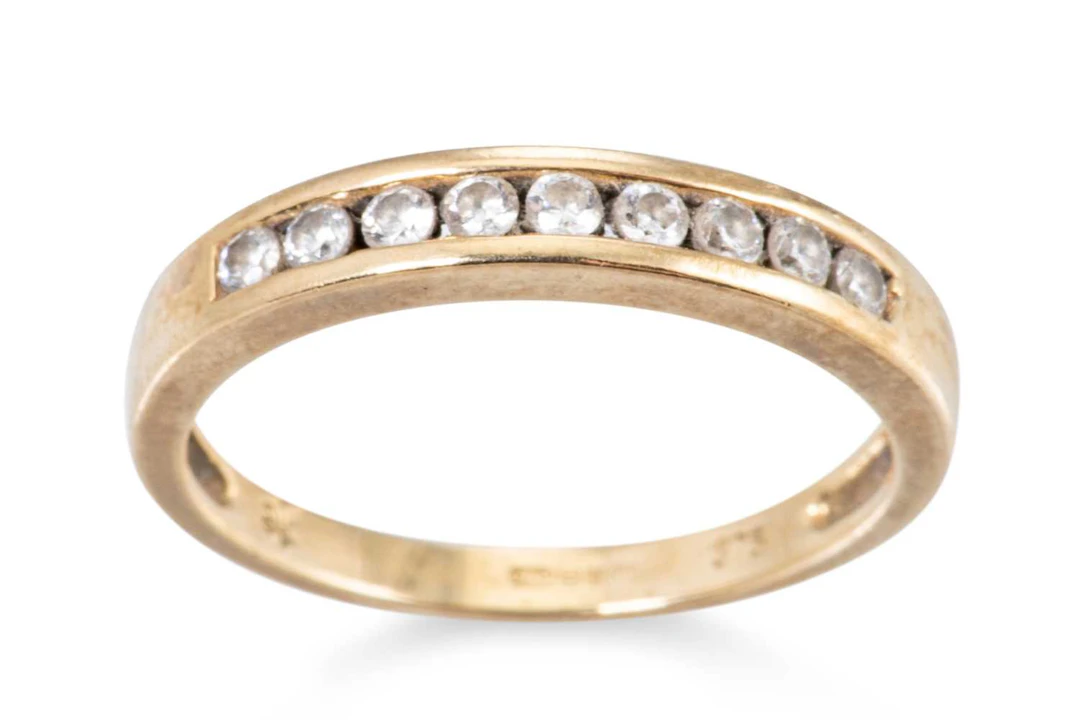 A 9CT YELLOW GOLD AND CUBIC ZIRCONIA BAND RING