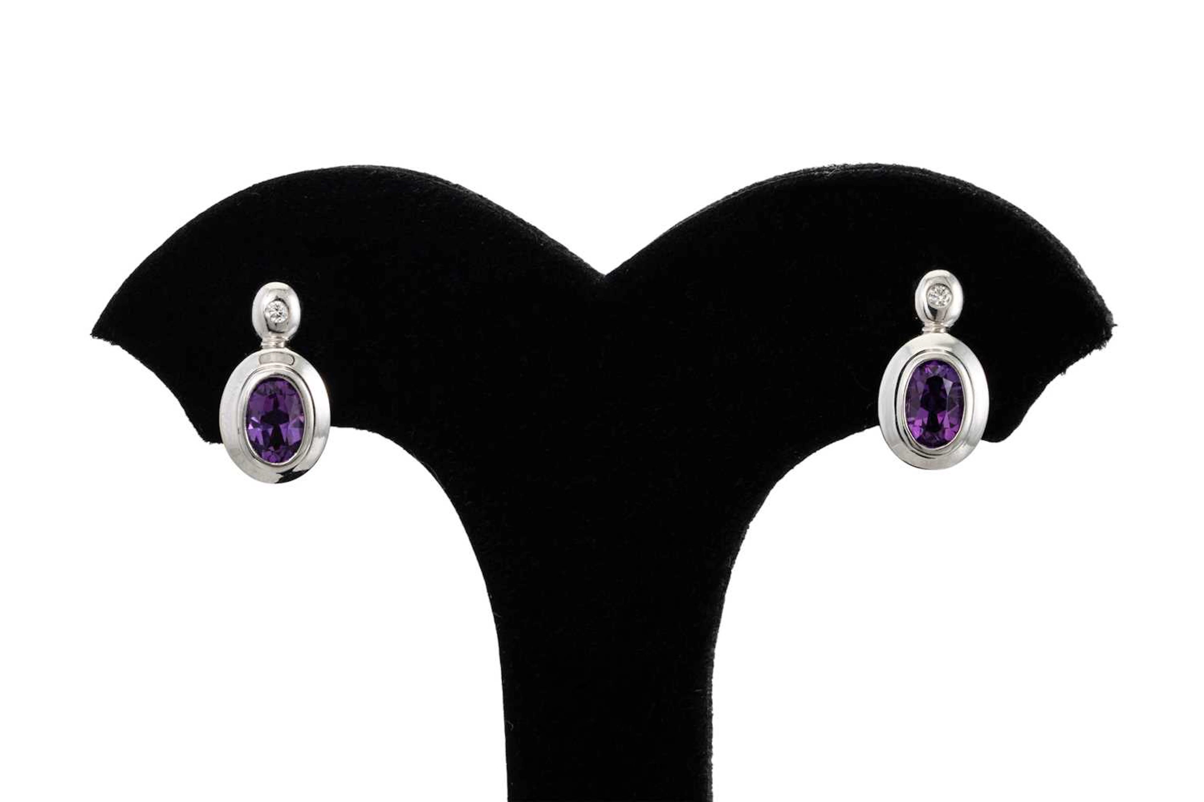 A PAIR OF DIAMOND AND AMETHYST EARRINGS