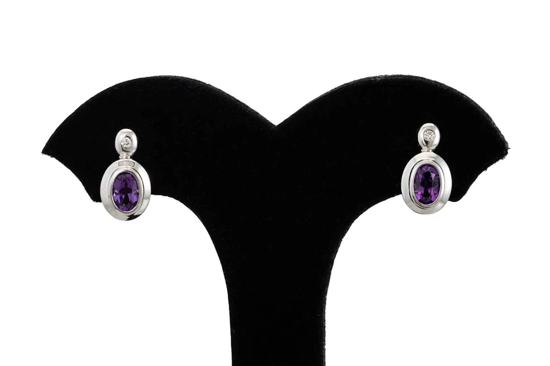 A PAIR OF DIAMOND AND AMETHYST EARRINGS