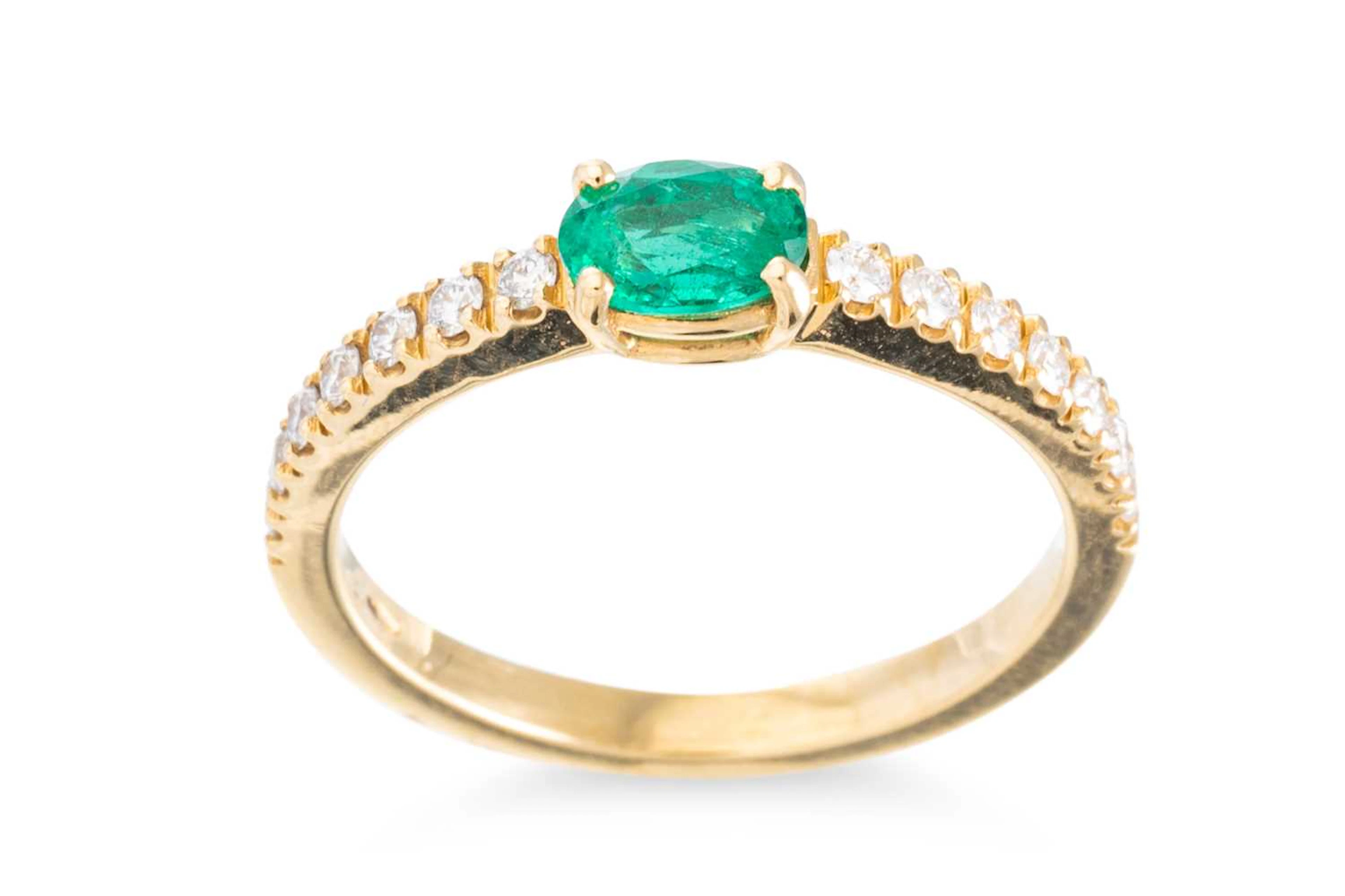 AN EMERALD AND DIAMOND SET BAND RING