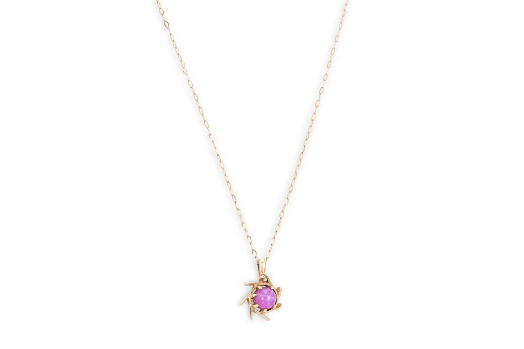 A GOLD AND SYNTHETIC STAR CABOCHON RUBY PENDANT