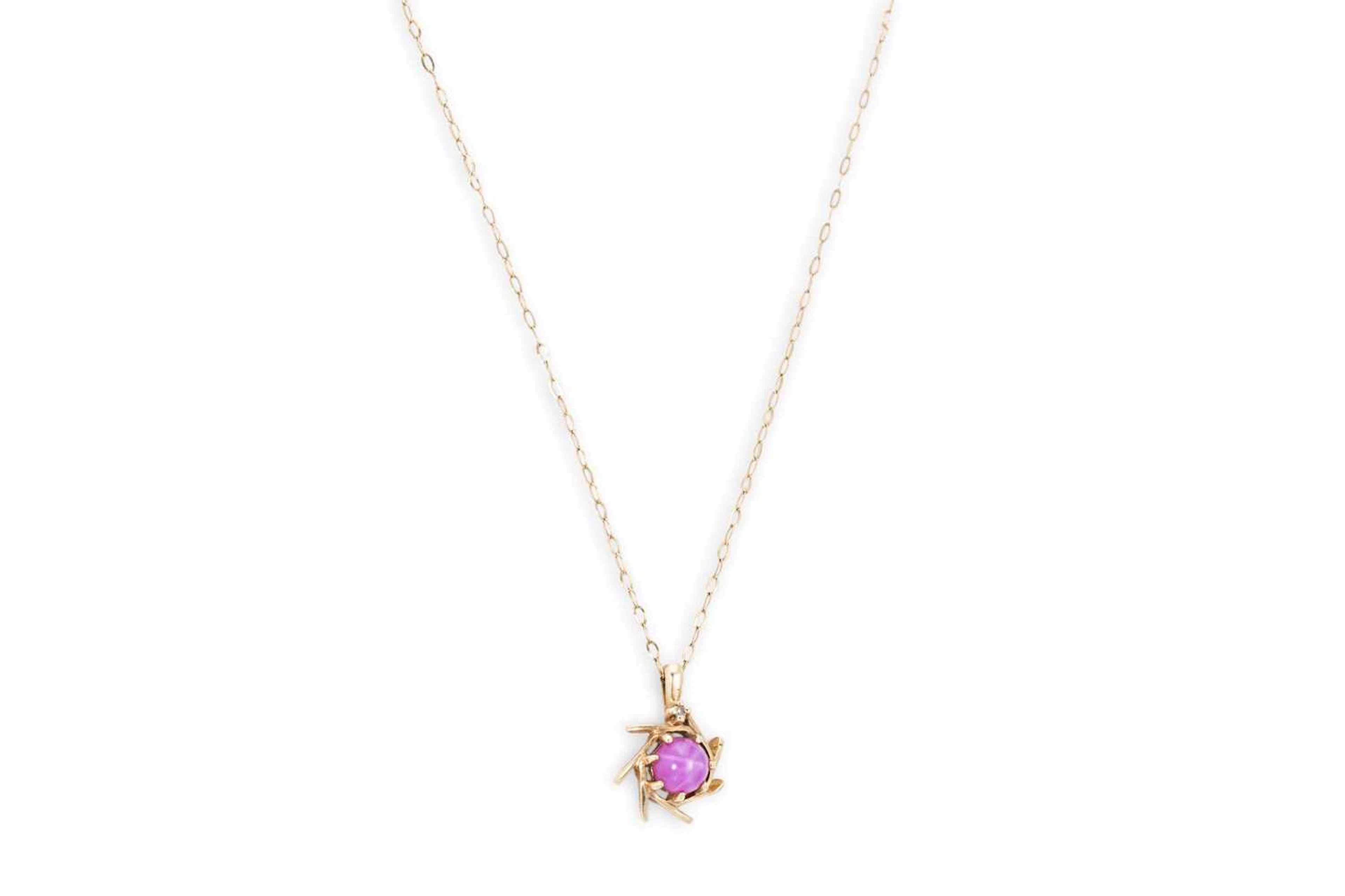 A GOLD AND SYNTHETIC STAR CABOCHON RUBY PENDANT