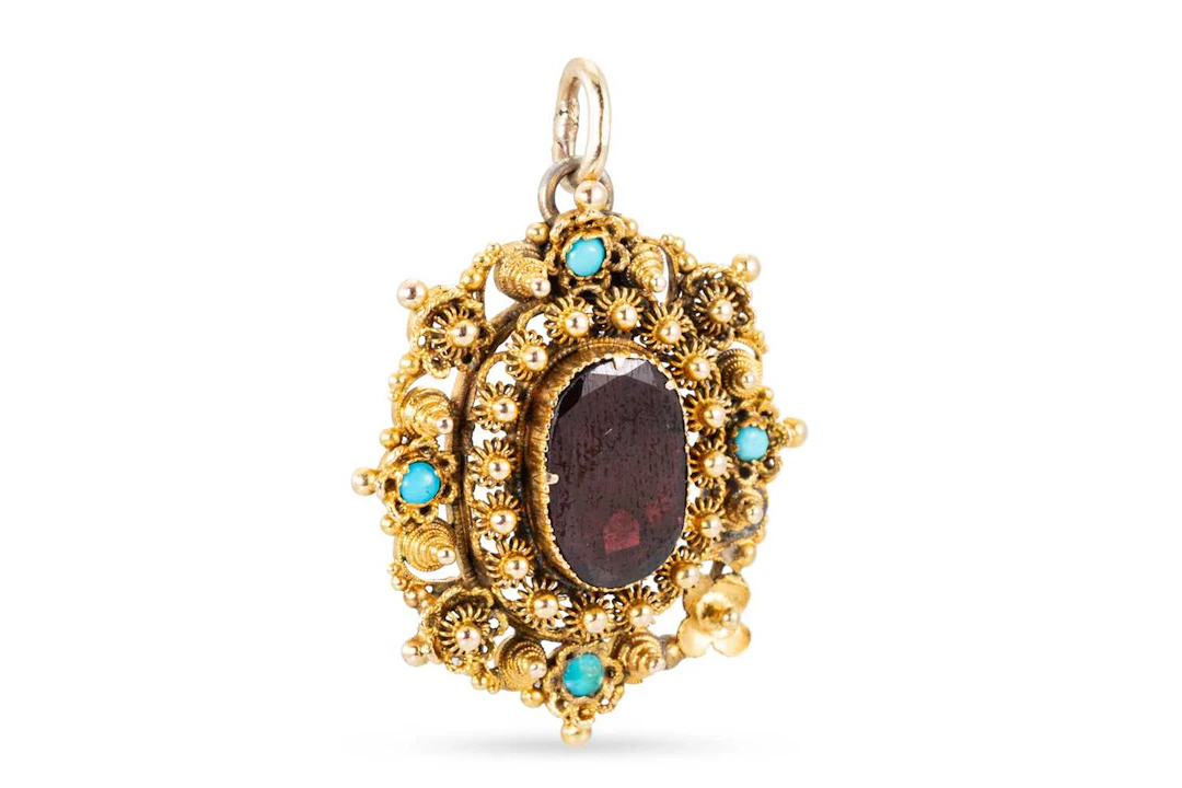AN ANTIQUE FOIL BACKED CANETTILLE WORK PENDANT