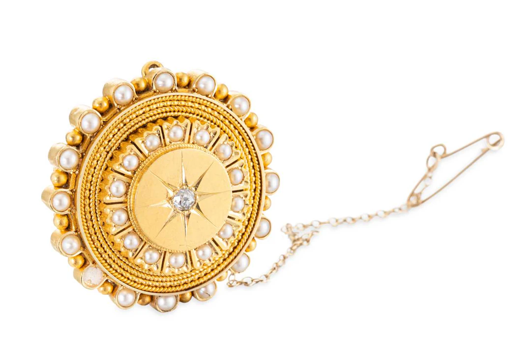 AN ANTIQUE GOLD CIRCULAR BROOCH